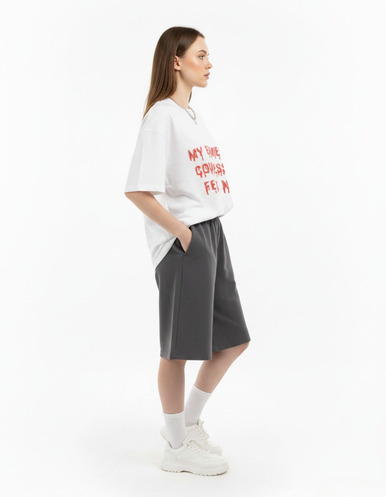 Women's oversized quote graphic t-shirt in white by GENZs Fashion, paired with grey baggy sweat-shorts.
