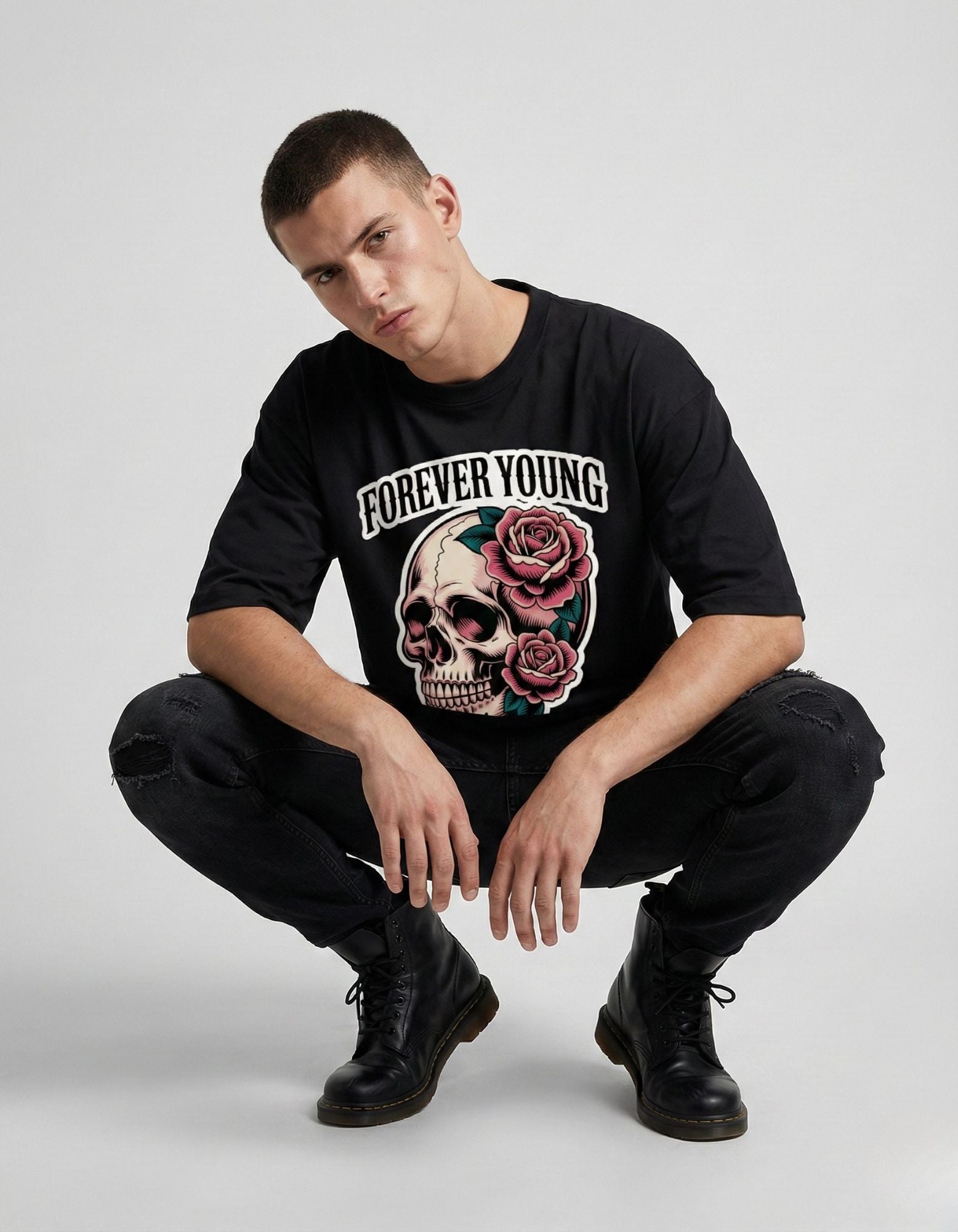 Aesthetic pose of a man wearing a black oversized streetwear tee with a rose skull design.