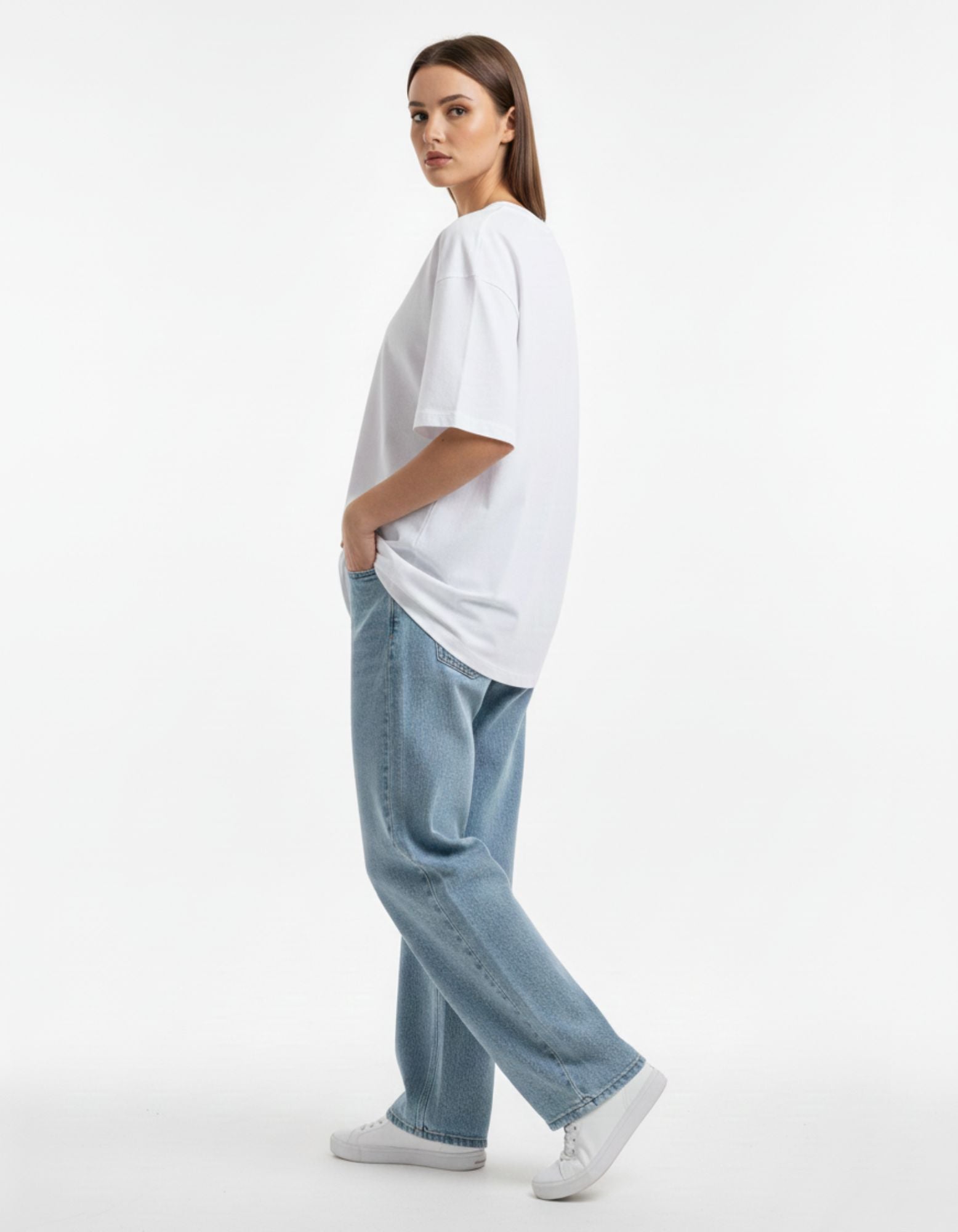 Back view of a premium white oversized t-shirt on a male model, showcasing the loose fit and streetwear silhouette.