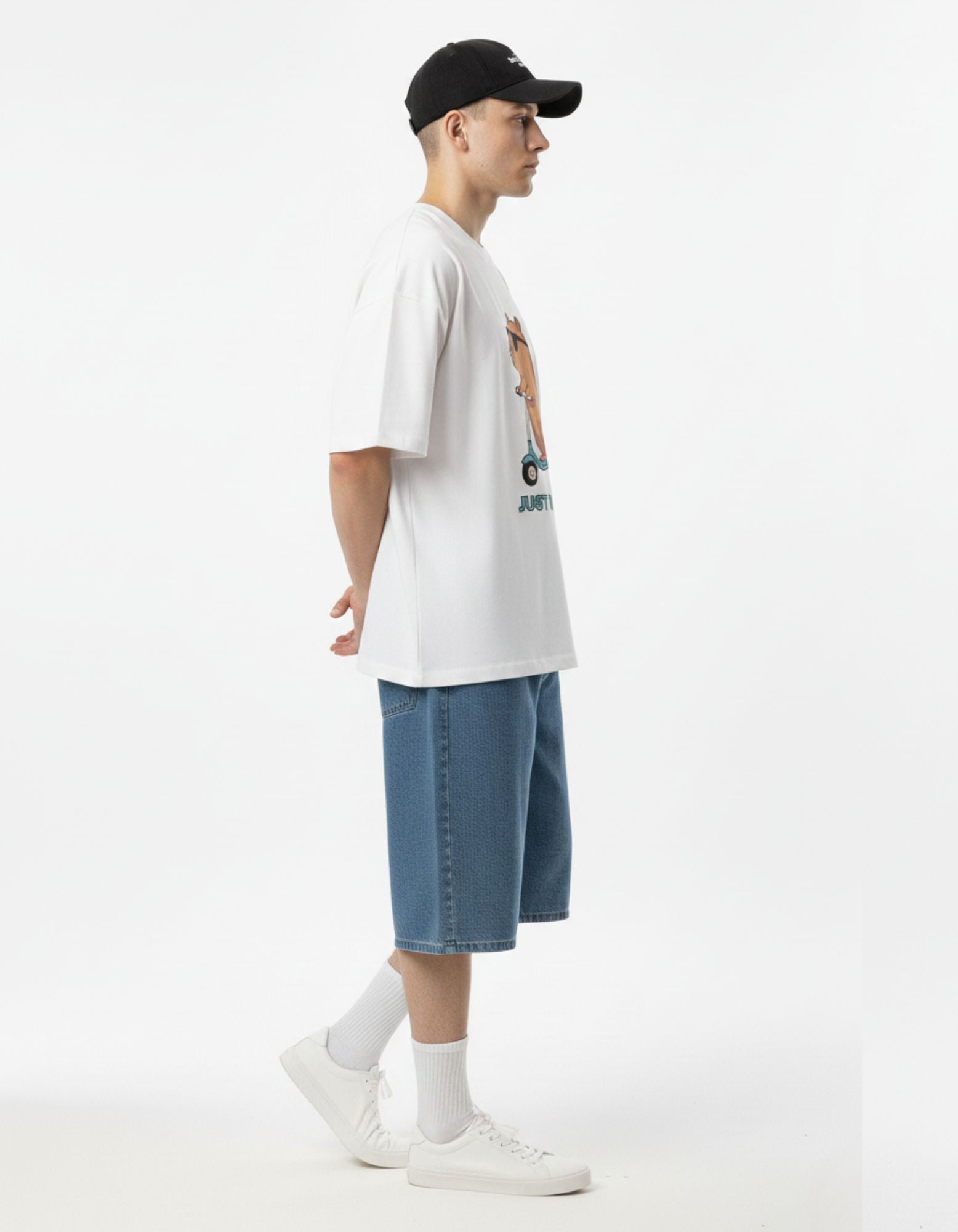 Side profile of a white oversized graphic t-shirt with a baggy fit, styled with denim shorts for a modern Gen Z aesthetic.