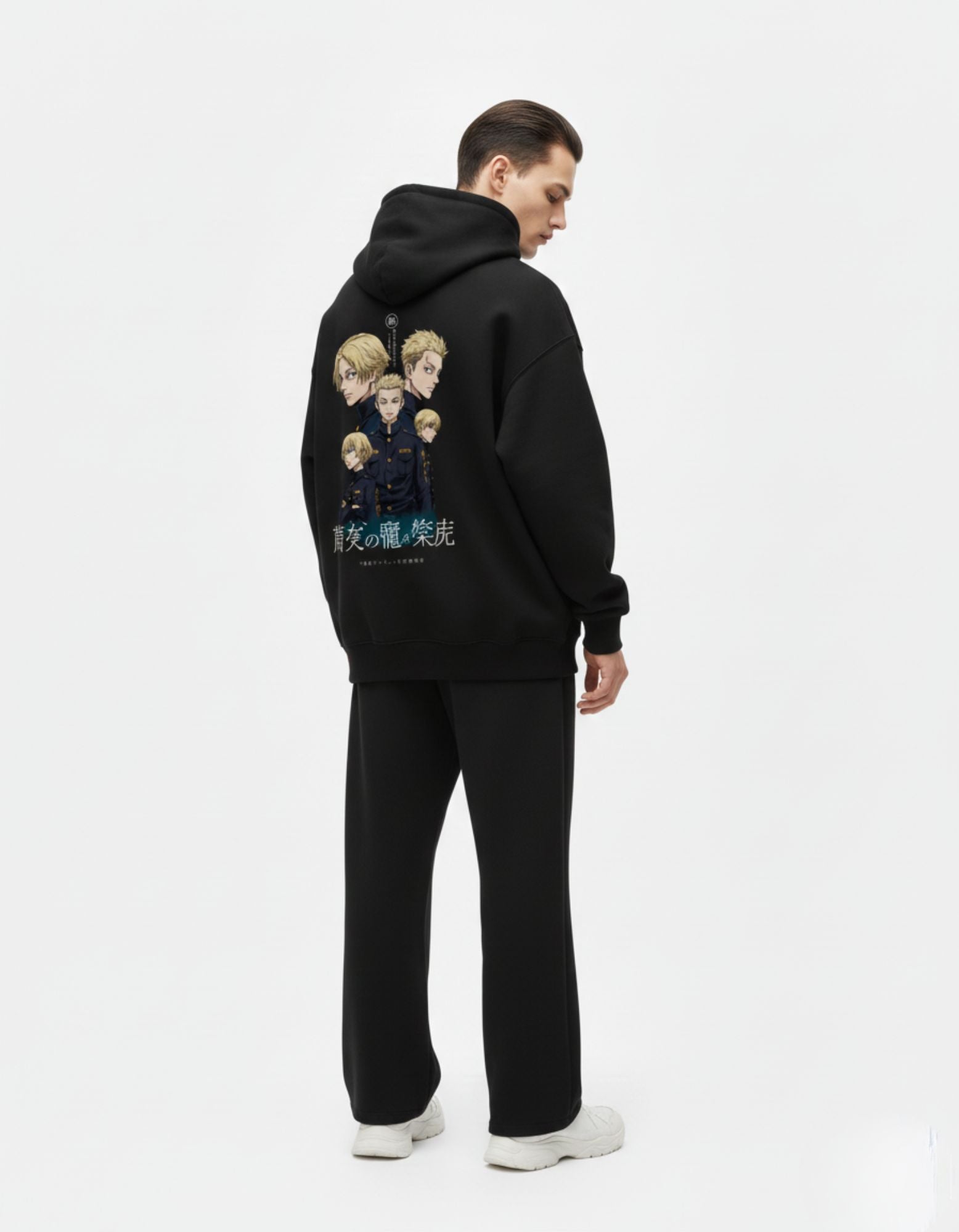 Full back view of a male model in a black graphic hoodie with a large anime-inspired illustration.