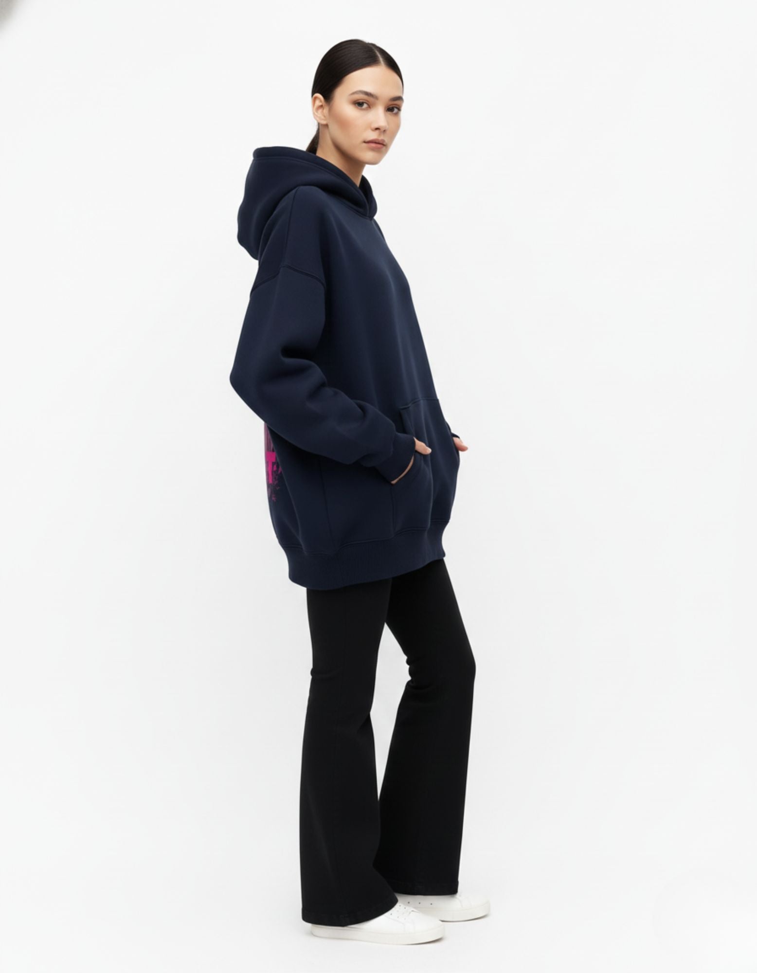 Full-length angled shot of a navy blue anime-themed oversized hoodie paired with black flared pants, showcasing a trendy urban streetwear outfit.