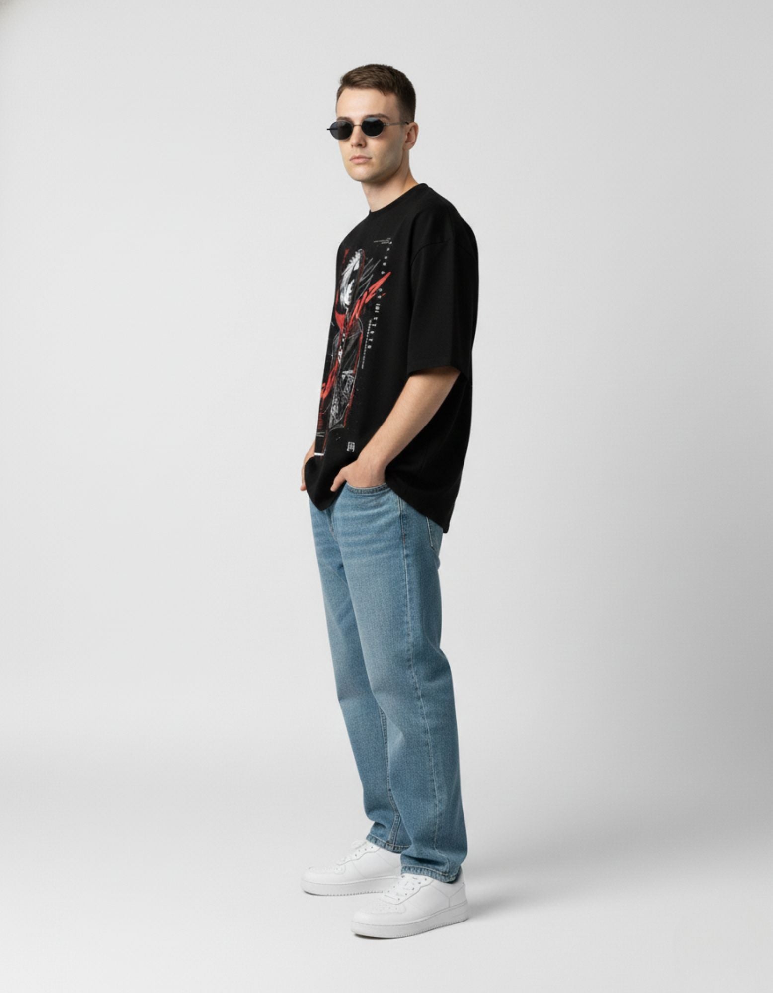 Side profile of a male model wearing a black graphic tee, showcasing the high-quality sleeve cut and loose fit.