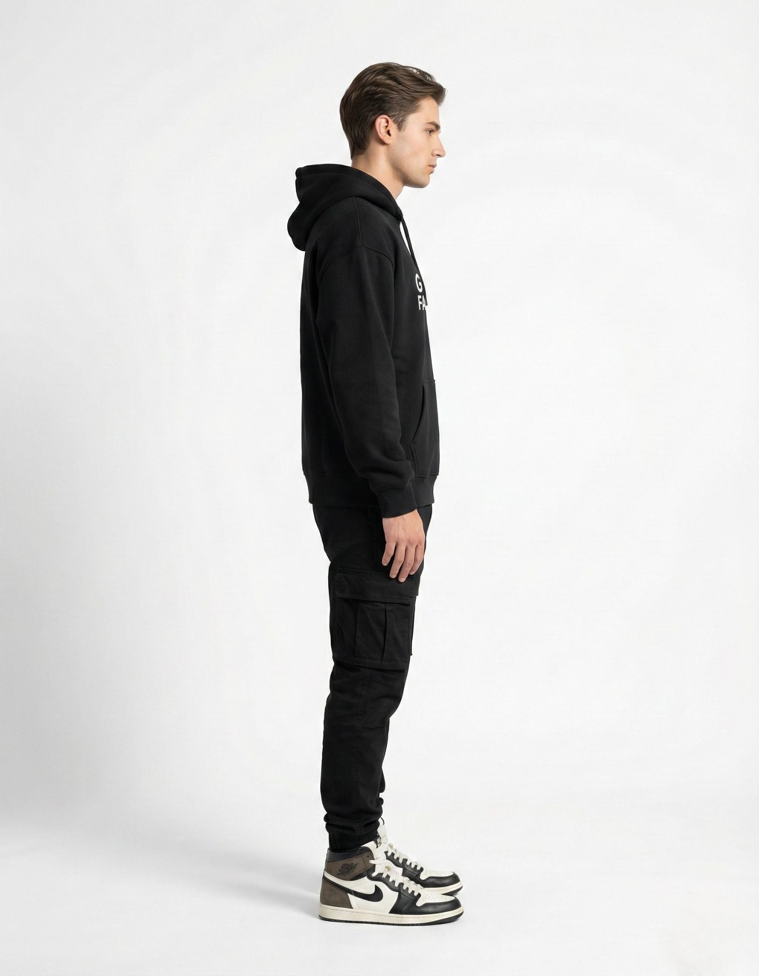 Side profile of a male model wearing a high-quality black hoodie by GENZs Fashion, perfect for minimalist winter layering.