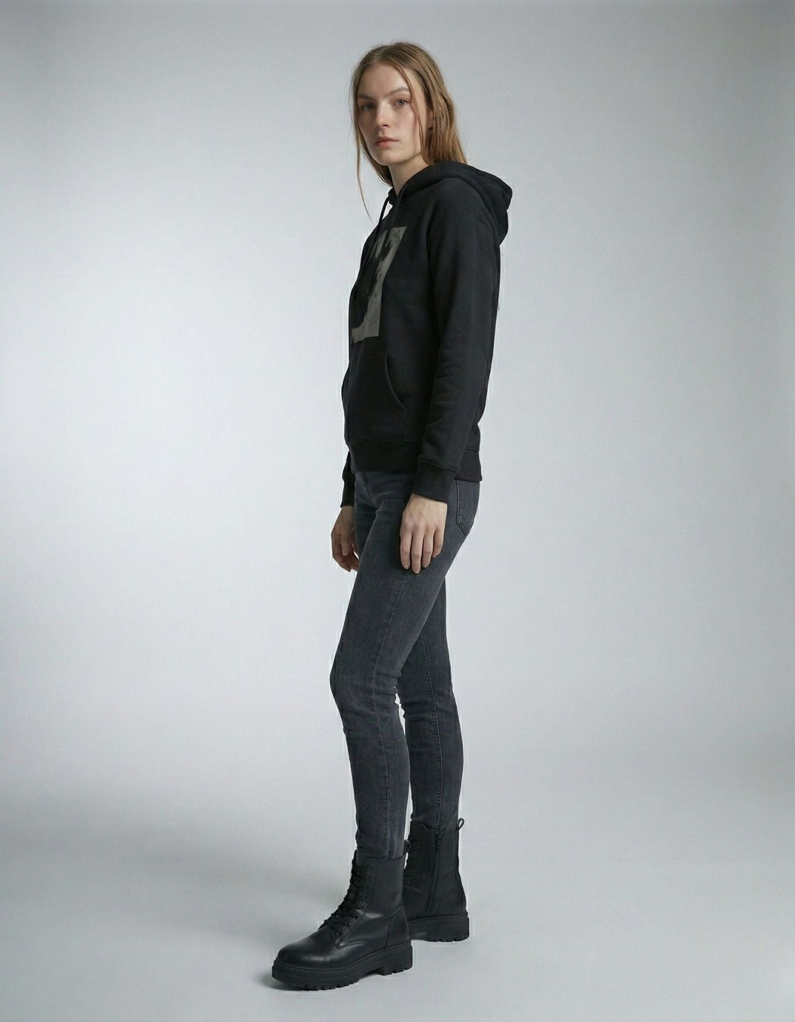 Side view of a woman wearing a black oversized hoodie with a modern graphic design from GENZs Fashion.