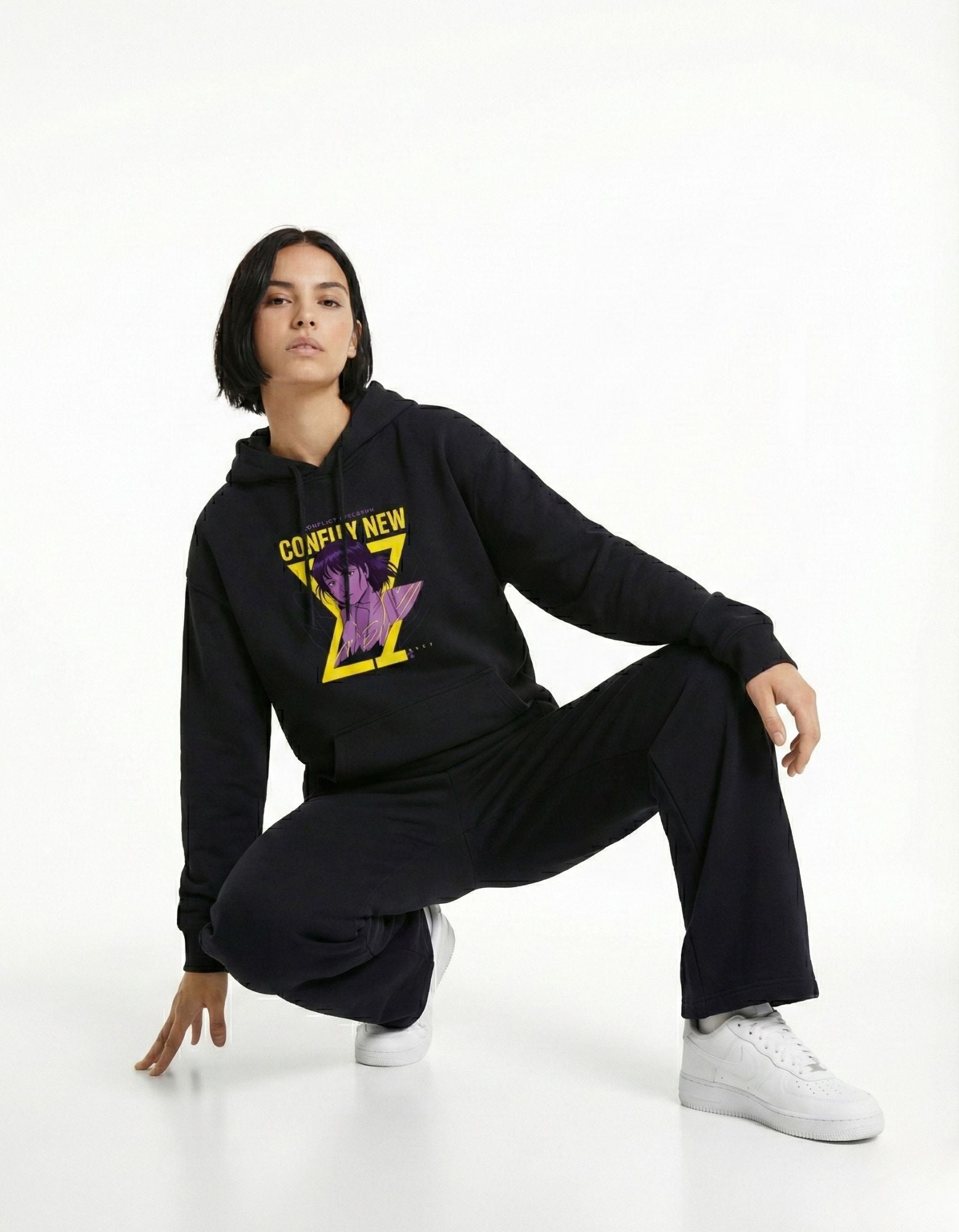 Black oversized hoodie with graphic print worn by female model in fashion pose
