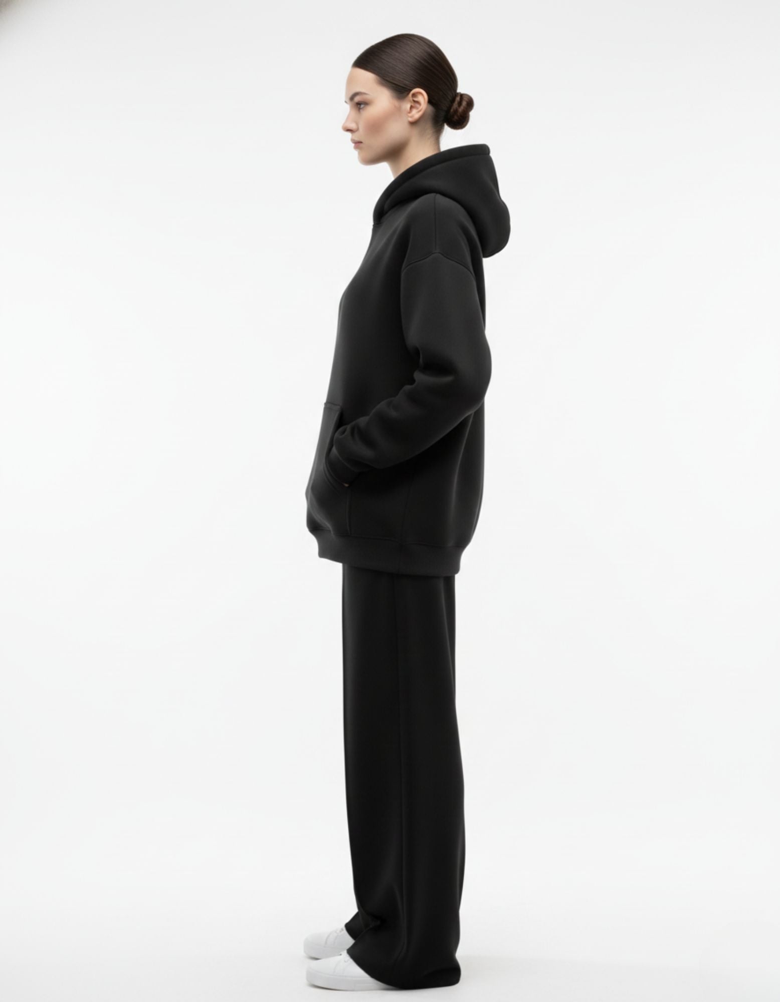 Side profile of black oversized hoodie worn by model
