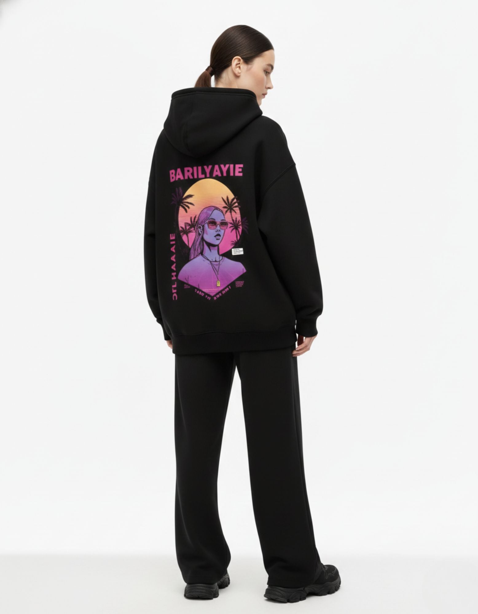 Back view of black oversized hoodie with anime print worn by female model