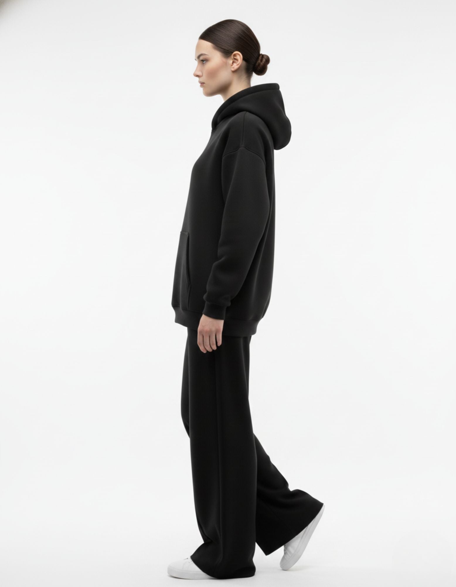 Side pose of black oversized hoodie showing relaxed oversized fit
