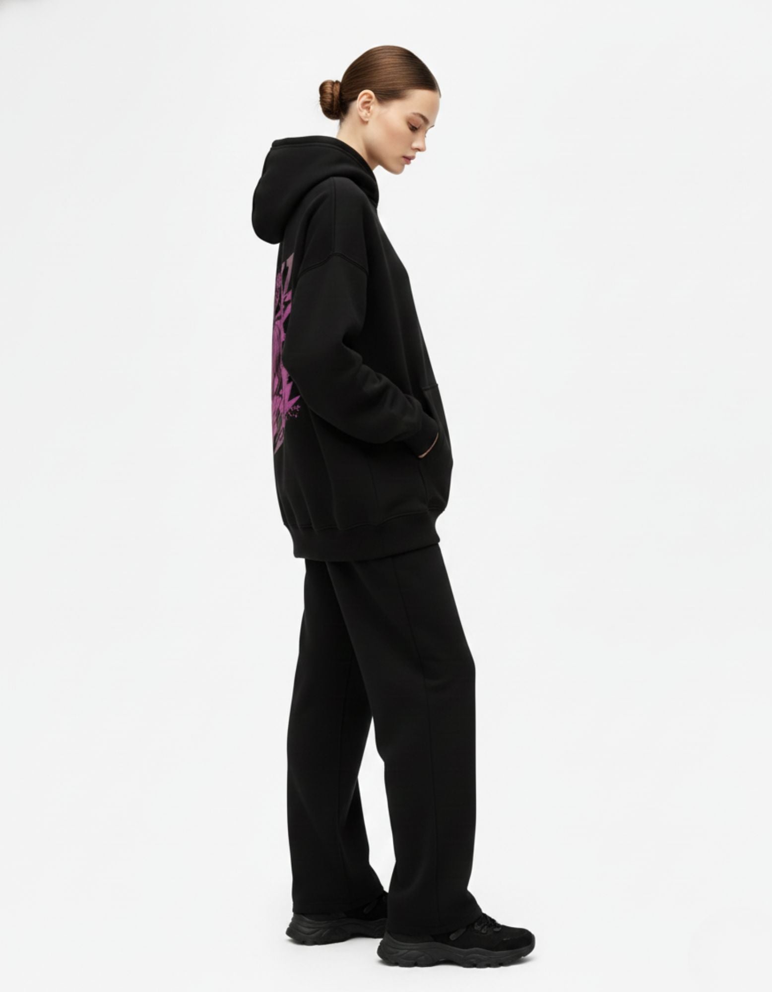 Side profile of black oversized hoodie worn in casual streetwear style
