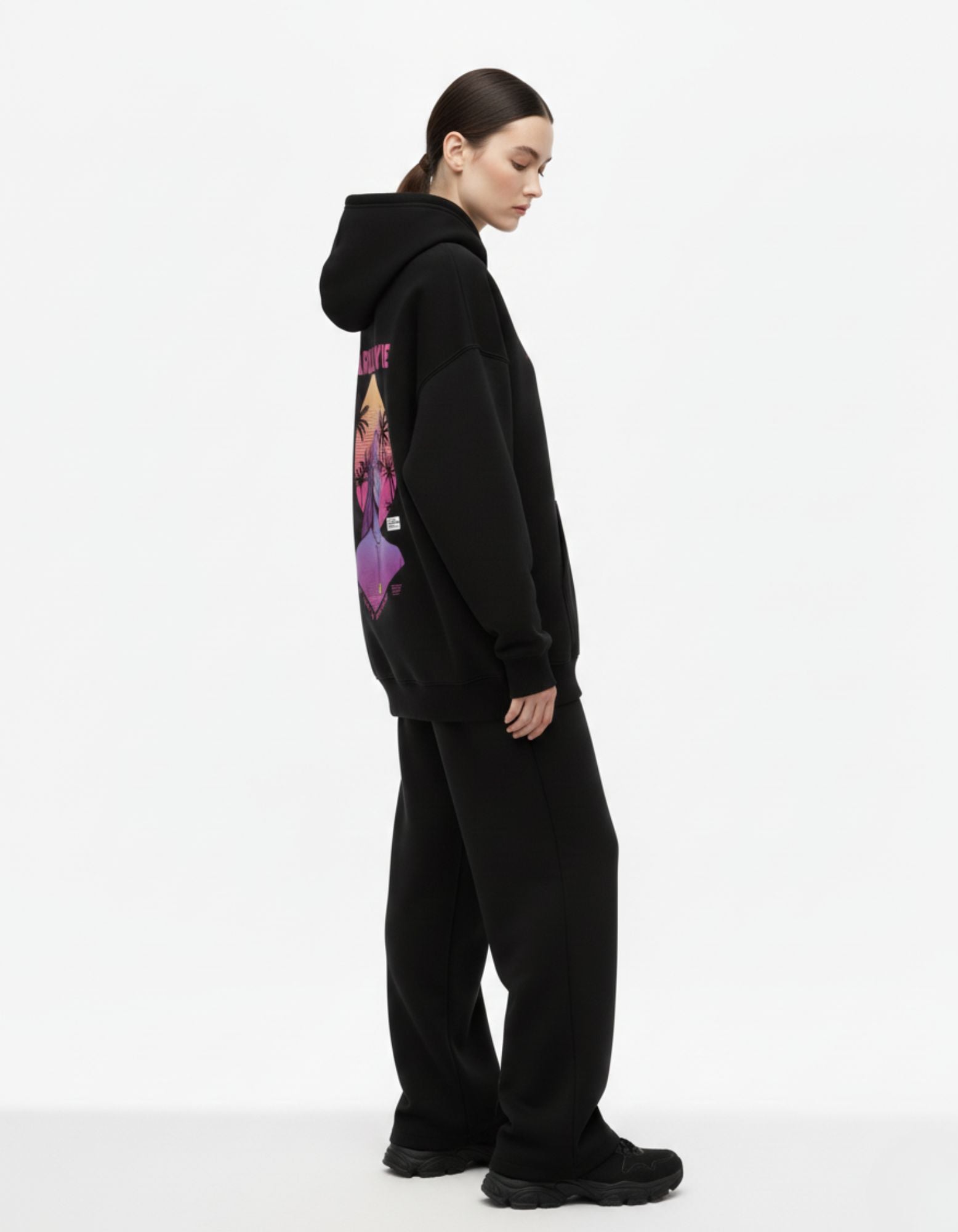 Side pose of black oversized hoodie showing relaxed streetwear fit