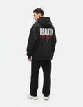 Back view of a male model wearing a premium black oversized hoodie from GENZs Fashion featuring a white 'REALITY' graphic with red drip effect.