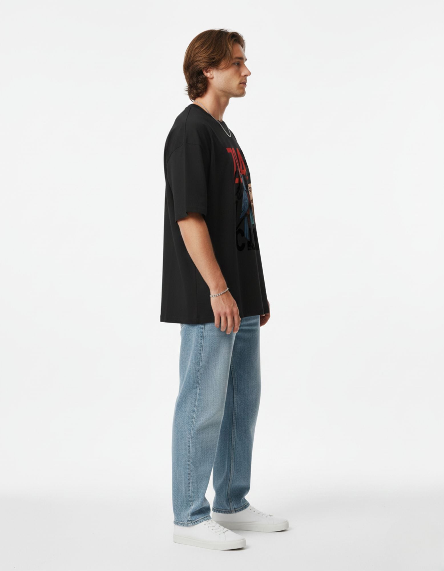 Female model with hands in pockets posing in a black oversized graphic tee, perfect for a casual streetwear look.