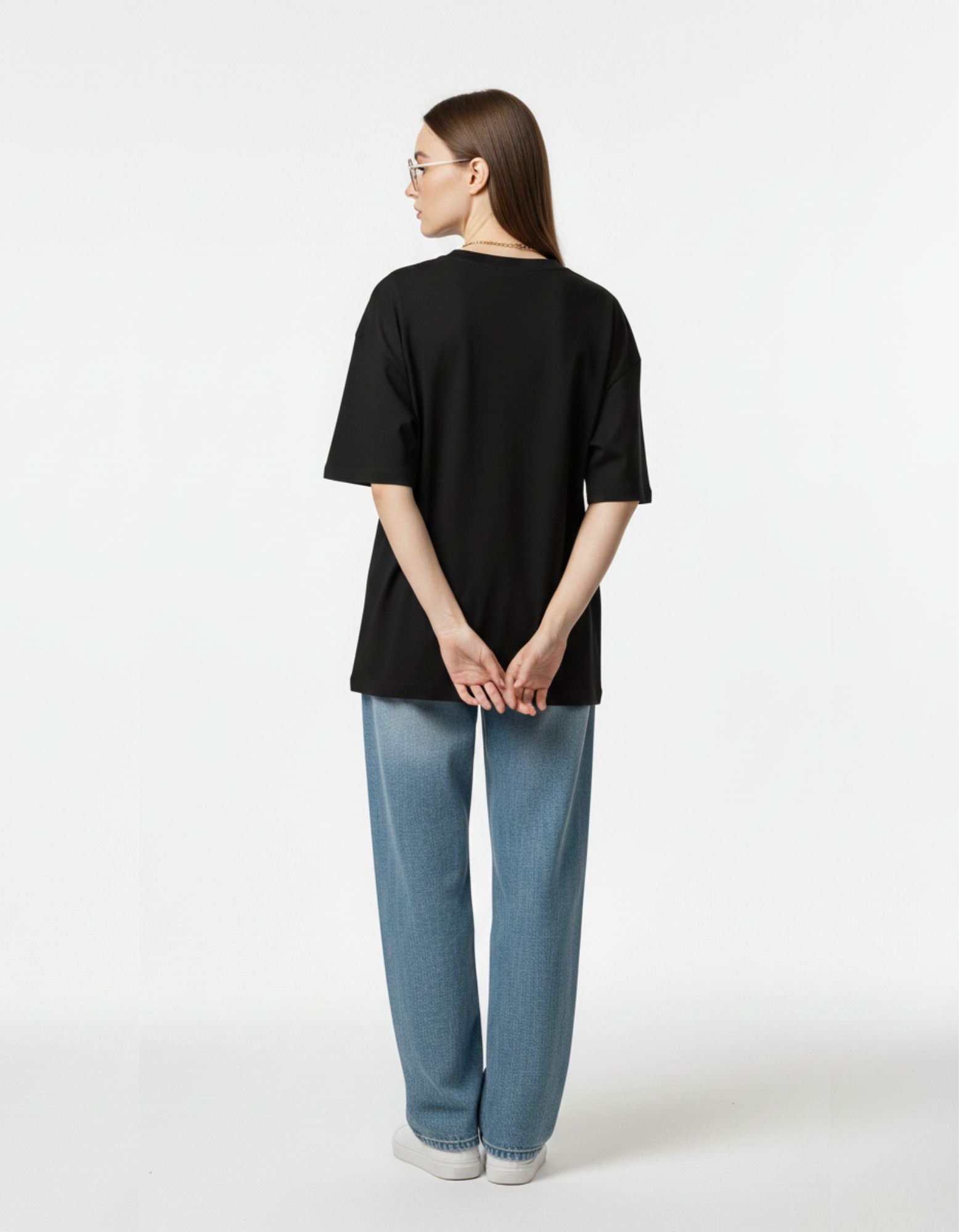 Back view of a premium black oversized t-shirt for women showing the high-quality dropped-shoulder fit and minimalist look.