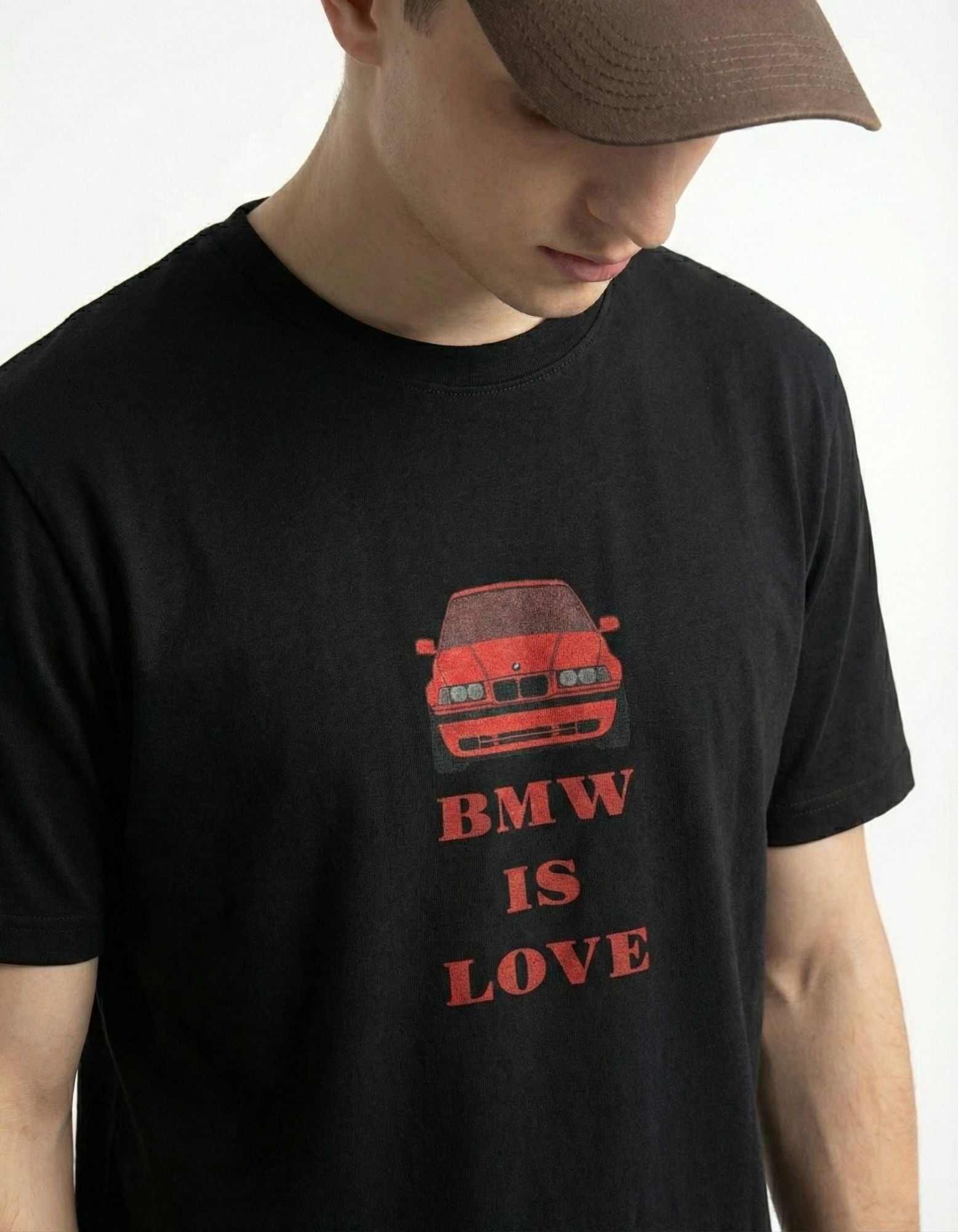 Close-up of 'BMW IS LOVE' red vintage car graphic on a premium black streetwear t-shirt by GENZs Fashion.