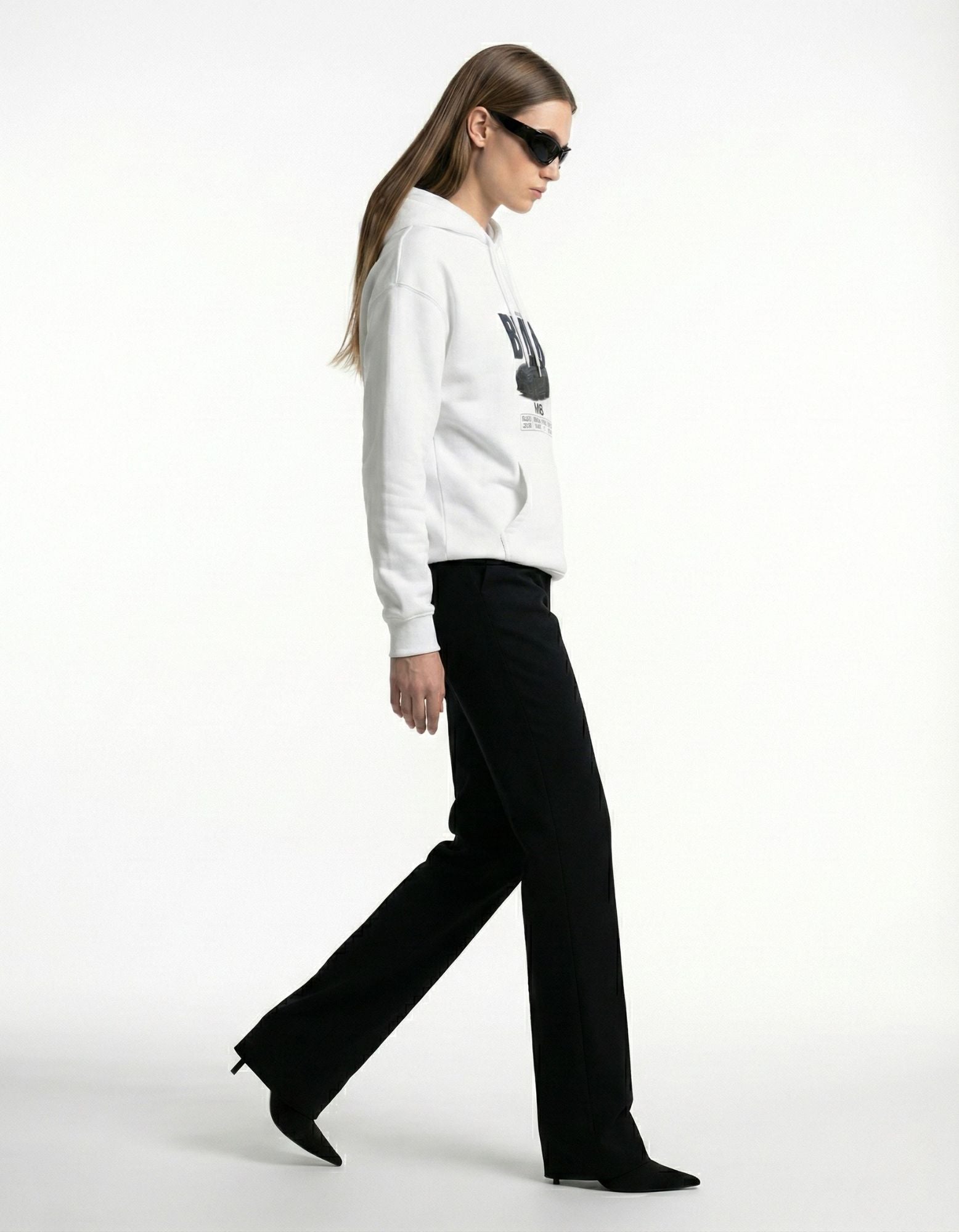 Lifestyle shot of a woman wearing the GENZs Fashion BMW M8 oversized hoodie, perfect for automotive events or casual wear.