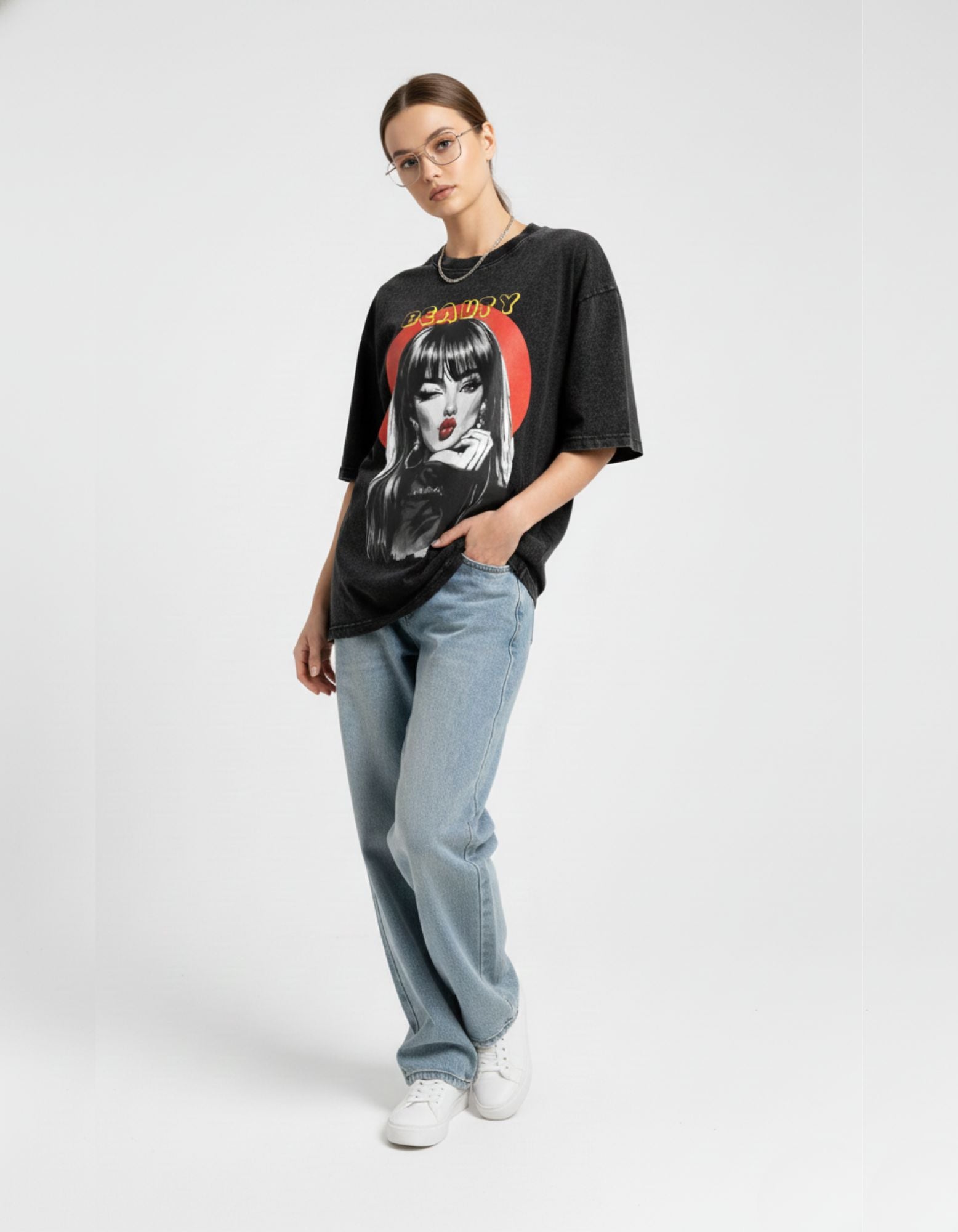 Trendy charcoal oversized graphic t-shirt with aesthetic 'Beauty' print styled with loose-fit jeans and sneakers.