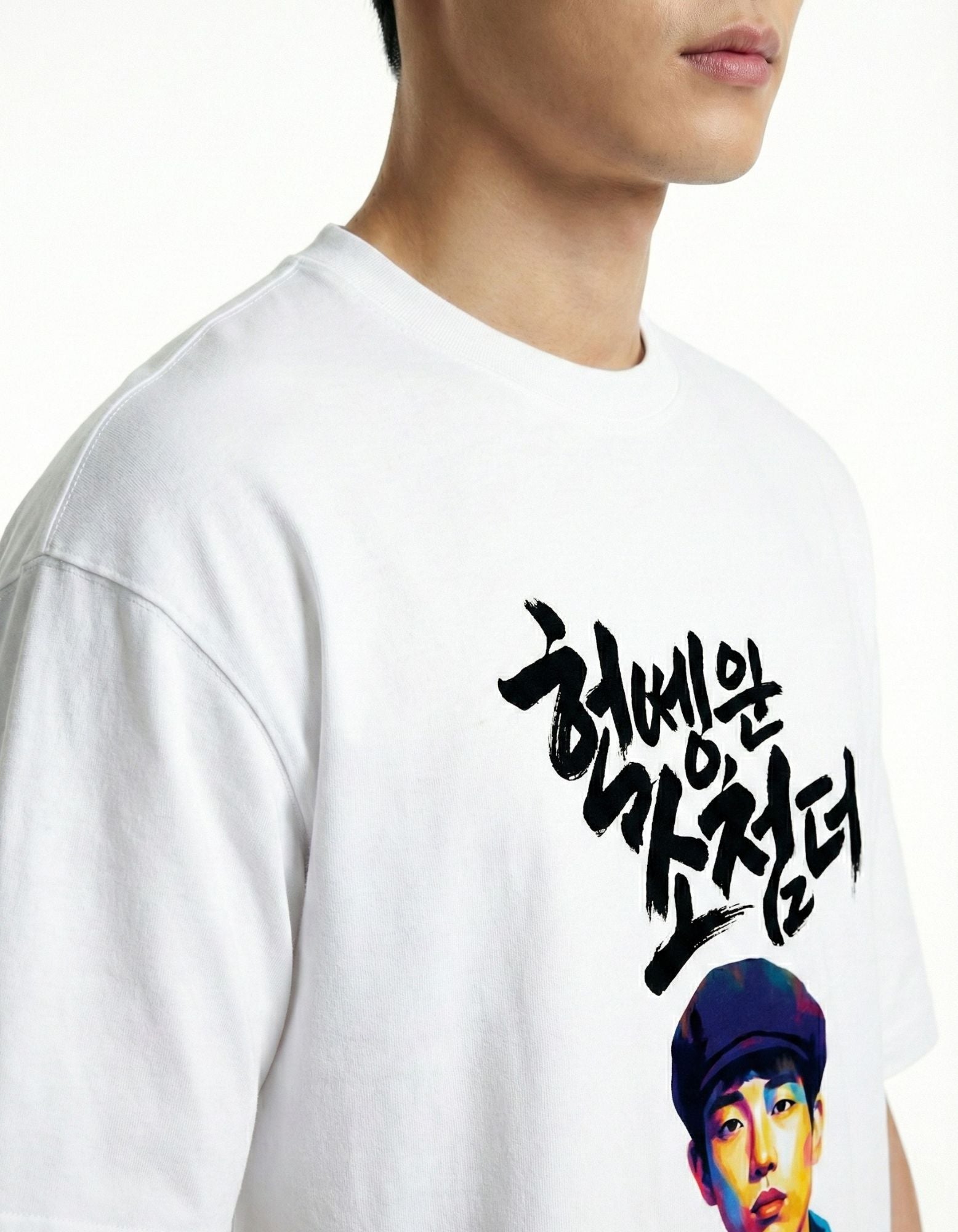 "Close-up detail of the high-quality Korean calligraphy and portrait print on a white oversized t-shirt."