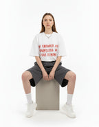Female model in a sitting pose wearing GENZs Fashion white 'Countless Fear' baggy tee, premium 240 GSM quality.