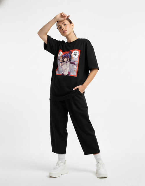 A female model posing in a black oversized anime streetwear tee featuring a high-quality colorful graphic print.