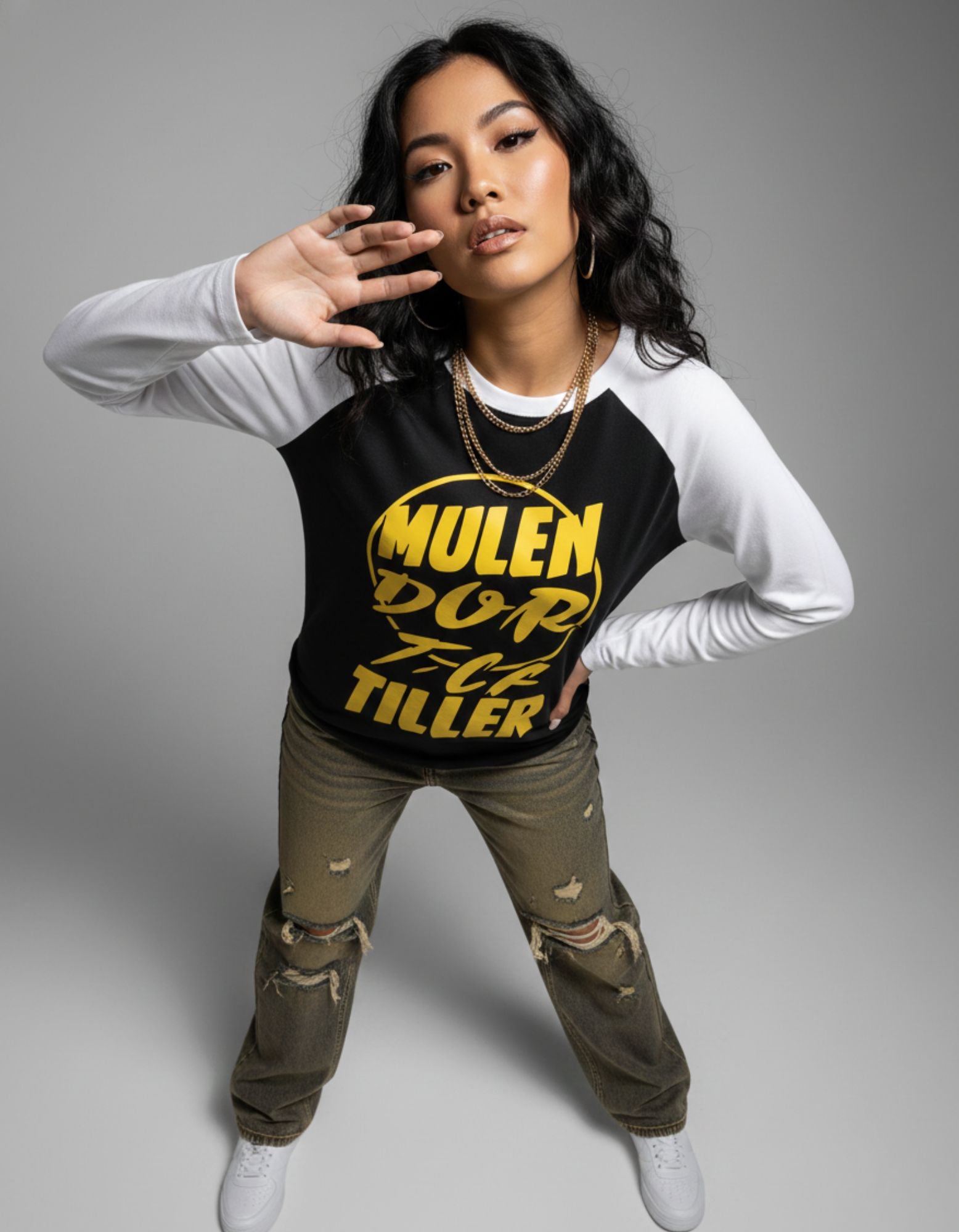 High-fashion editorial pose of model wearing GENZs Fashion raglan sleeve graphic tee, highlighting the bold yellow typography.
