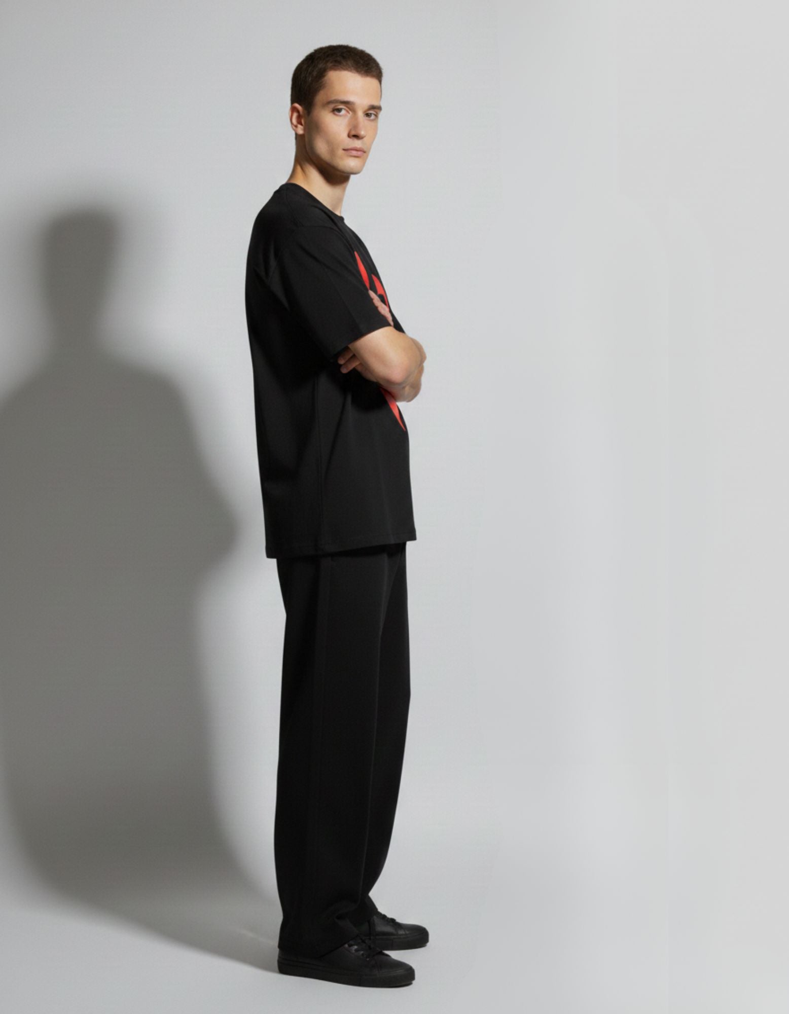 Side profile of male model in GENZs Fashion heavyweight black oversized t-shirt, ideal for a structured street style look.