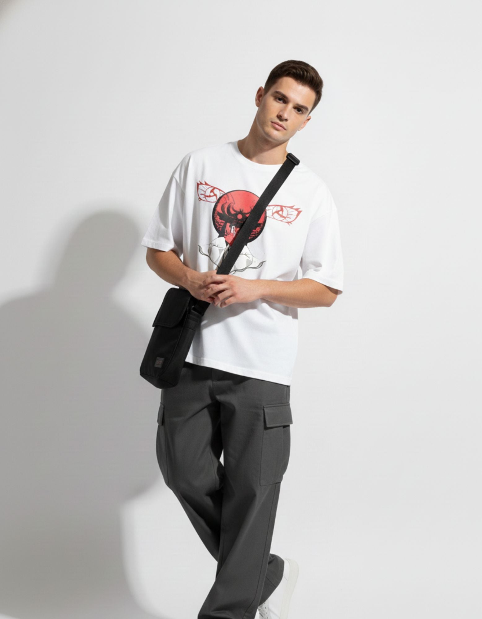 GENZs Fashion white baggy fit t-shirt with red anime graphic print, styled with a black crossbody bag for a premium streetwear look.