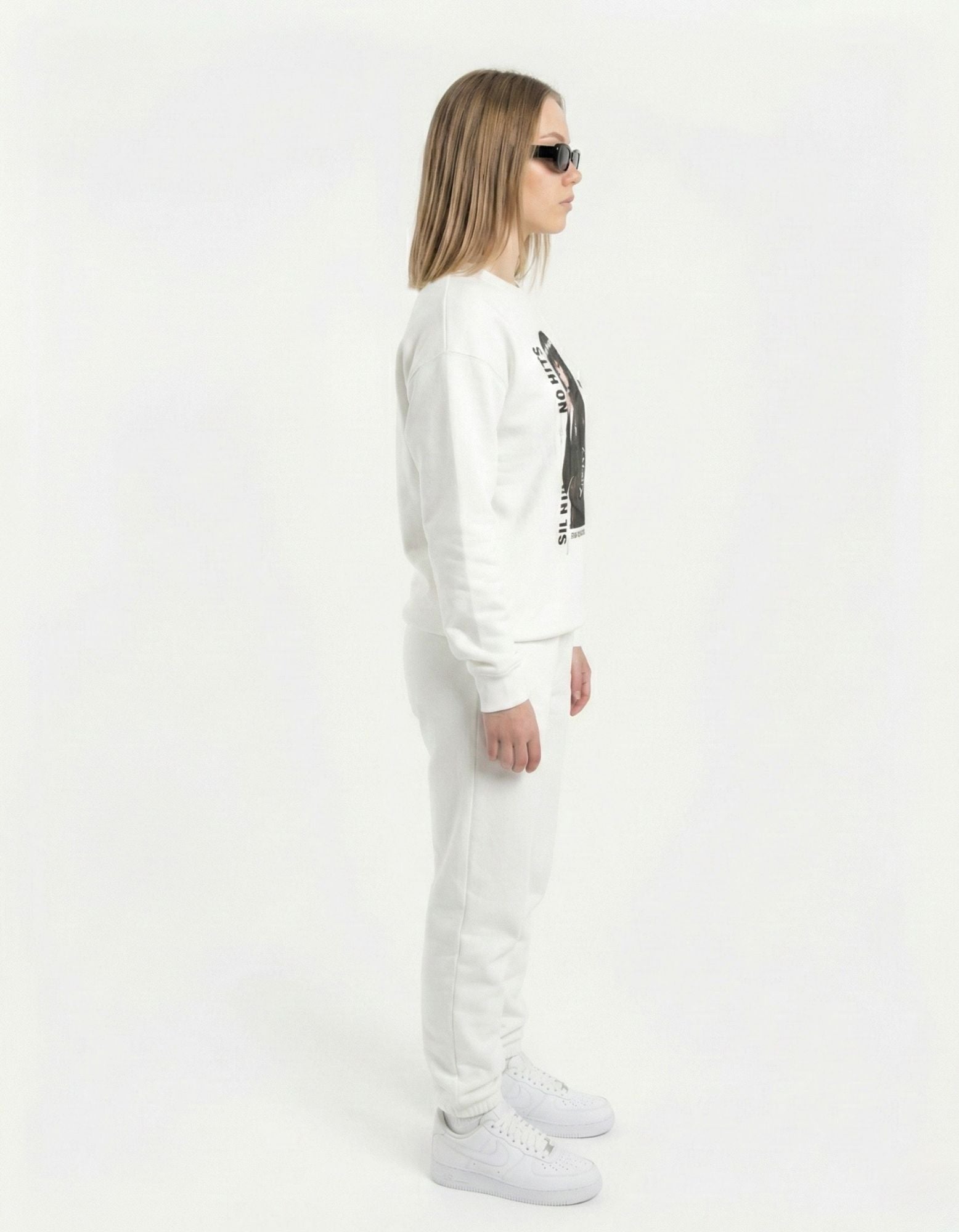 Side view of a model walking in a white 'Silent Vision' manga girl sweatshirt and matching white sweatpants.