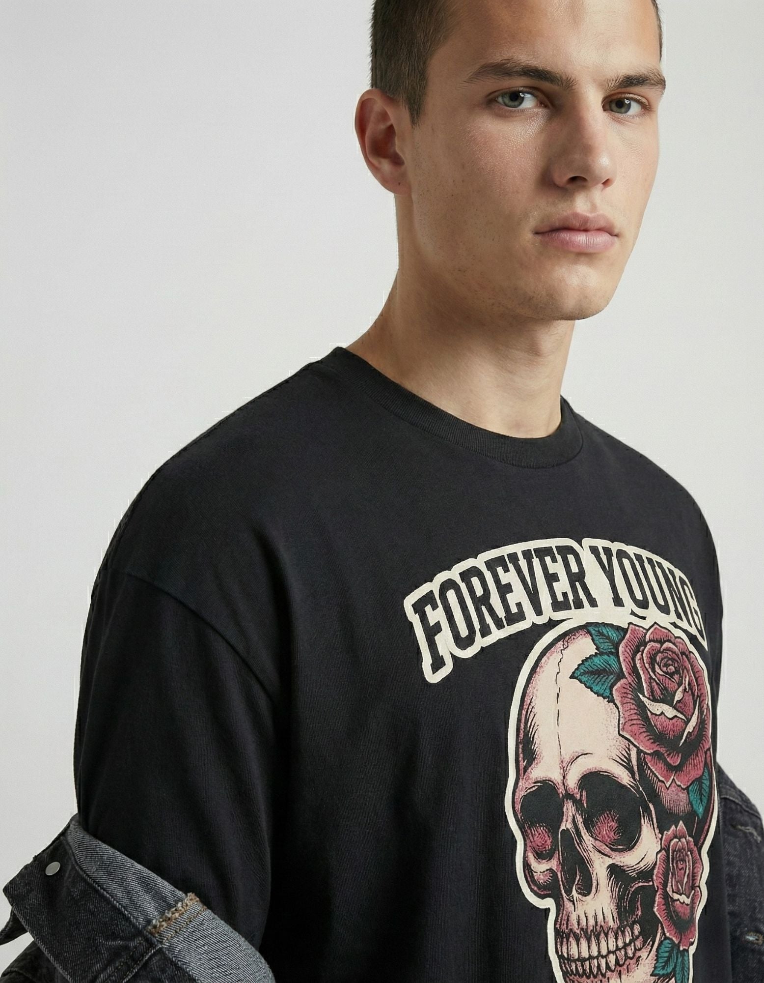 Close-up of Forever Young skull and rose graphic on black oversized t-shirt by GENZs Fashion India.