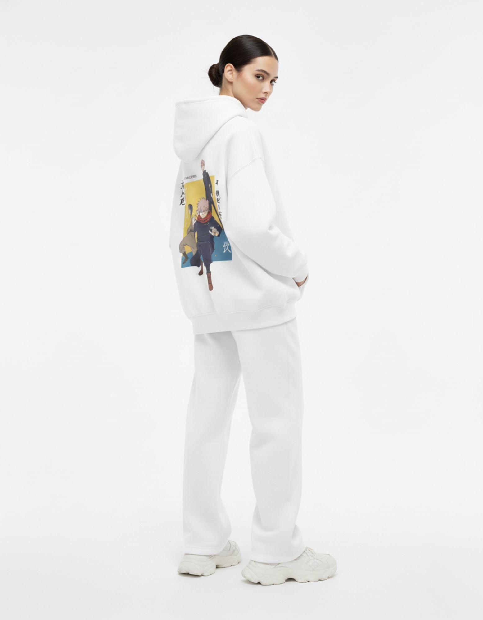 Female model wearing a GENZs Fashion unisex Jujutsu Kaisen graphic hoodie in white, styled as trendy streetwear with matching joggers.