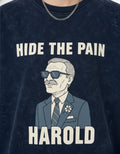 Close-up of Hide the Pain Harold meme graphic on navy blue acid wash t-shirt.