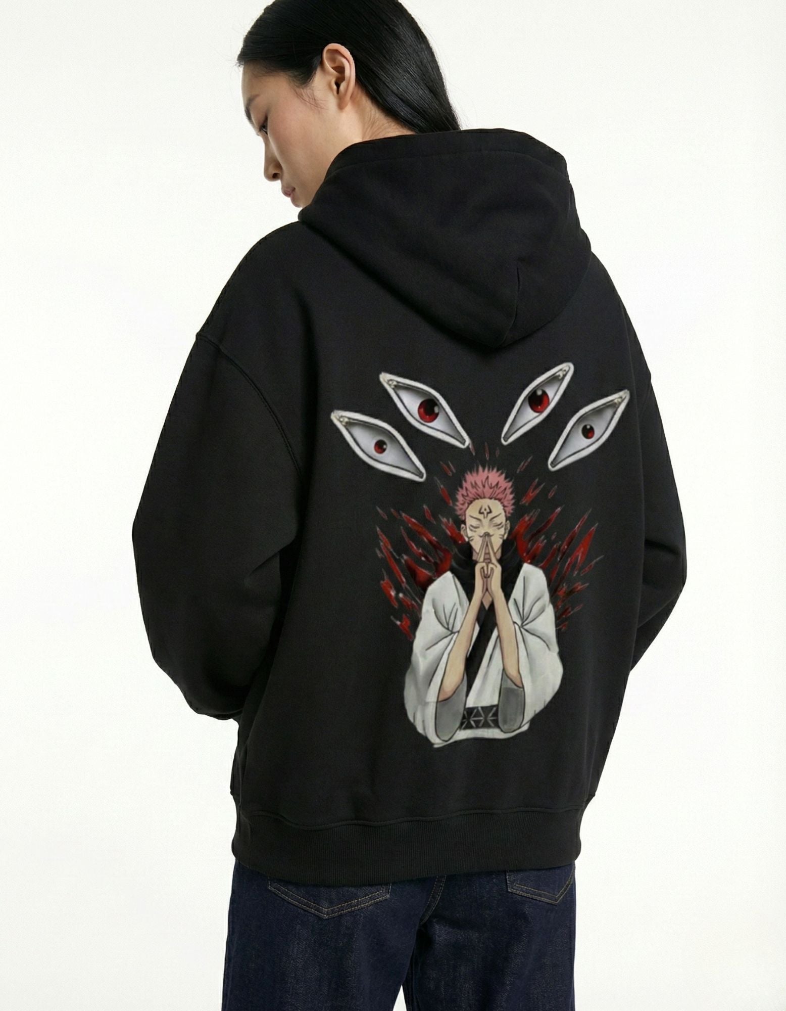 Close-up of the back print on a black streetwear hoodie showing Ryomen Sukuna's eyes and Malevolent Shrine inspired aesthetic.