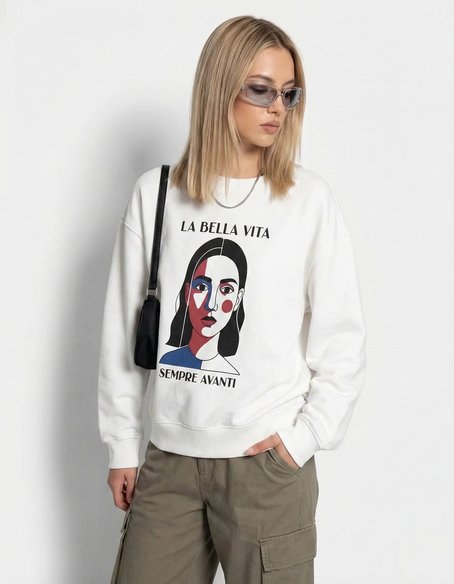 Close-up of a white 'La Bella Vita' sweatshirt featuring a vibrant minimalist face graphic and 'Sempre Avanti' text.
