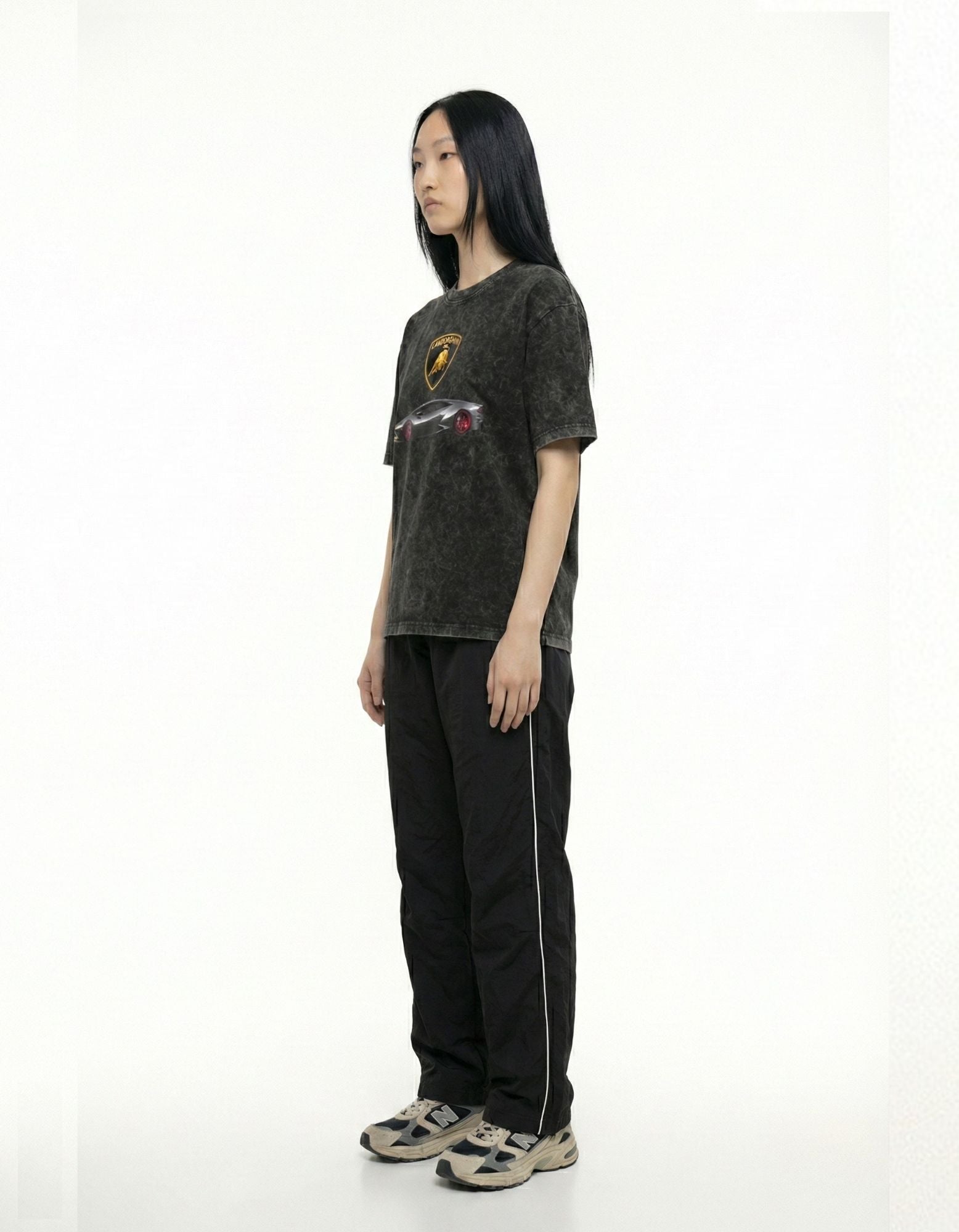 Side view of a washed black supercar graphic t-shirt styled with black joggers for an urban aesthetic outfit.