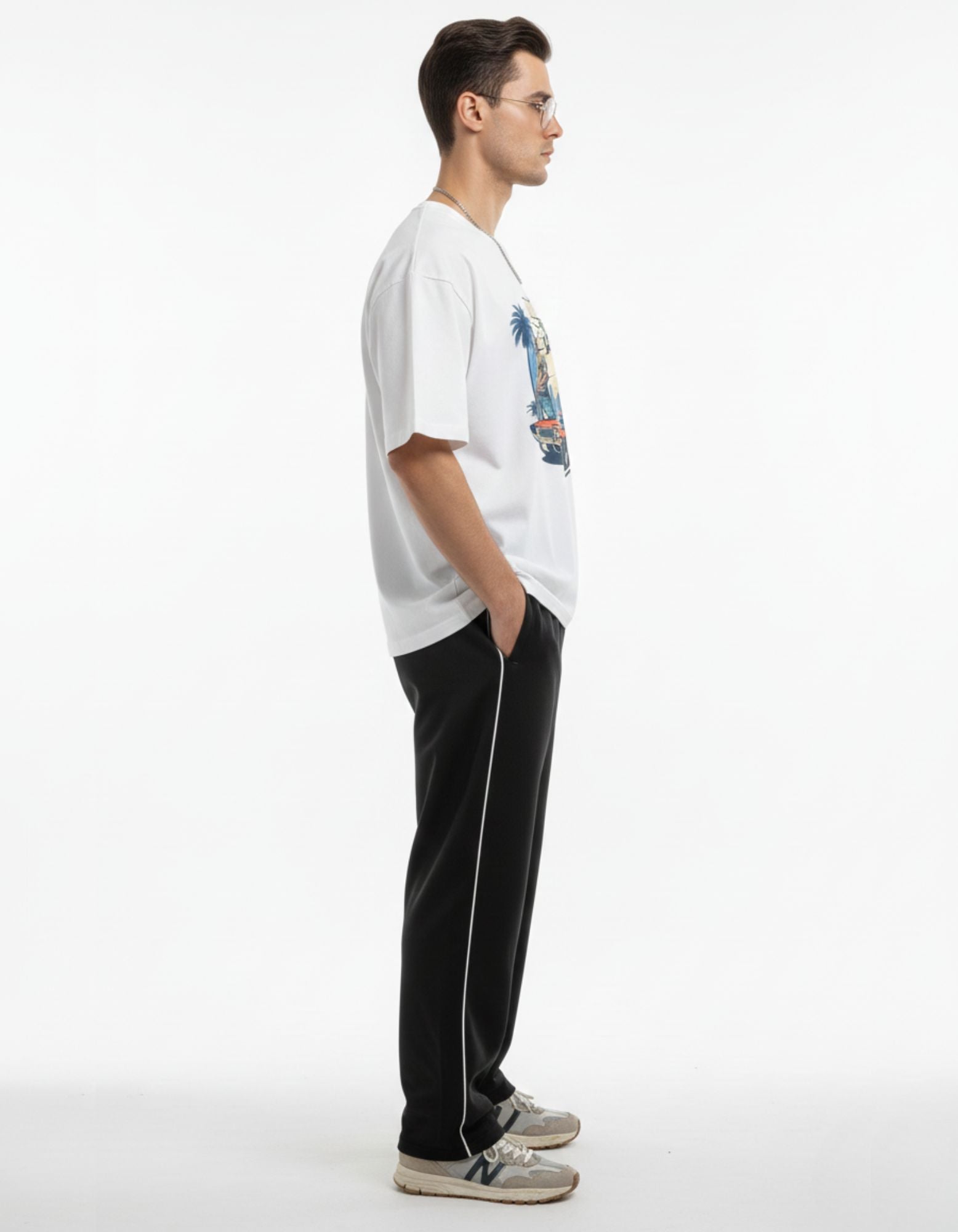 Side view of man in white oversized graphic tee, showing relaxed fit and premium fabric.