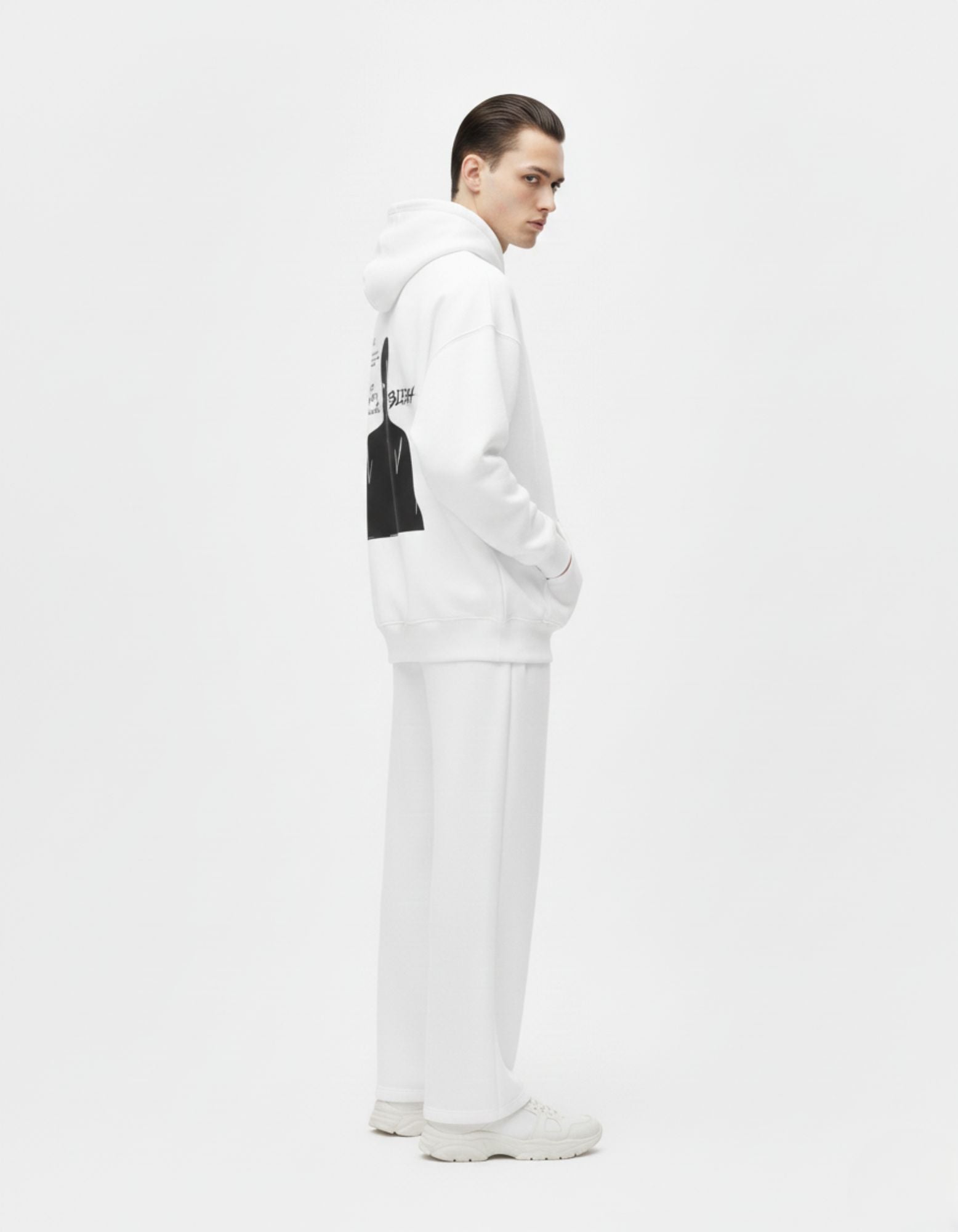 Side view of a male model in a white GENZs Fashion oversized hoodie, minimal streetwear aesthetic.