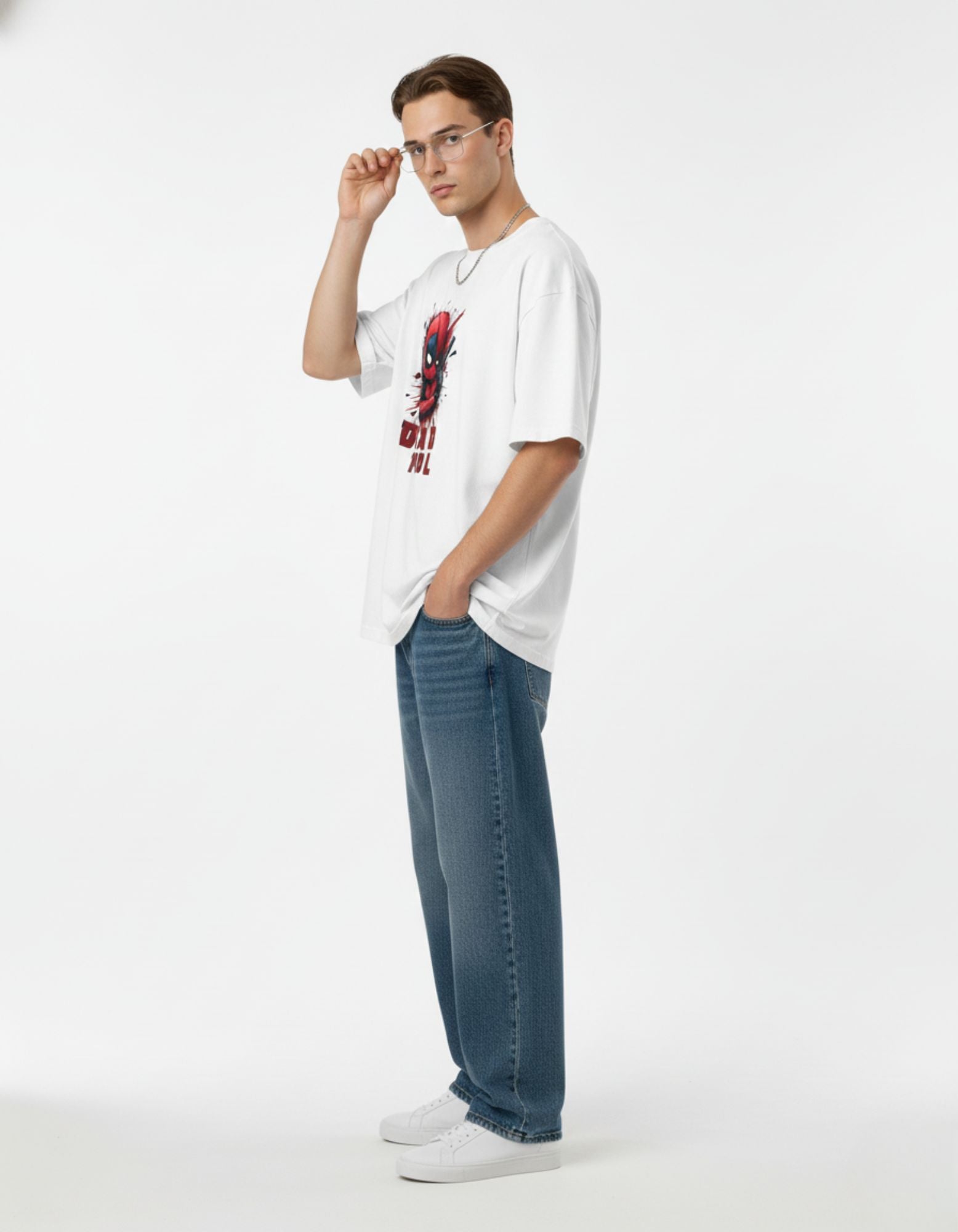 Side view of man in white Deadpool graphic tee and blue denim, a popular oversized streetwear look for Indian youth.