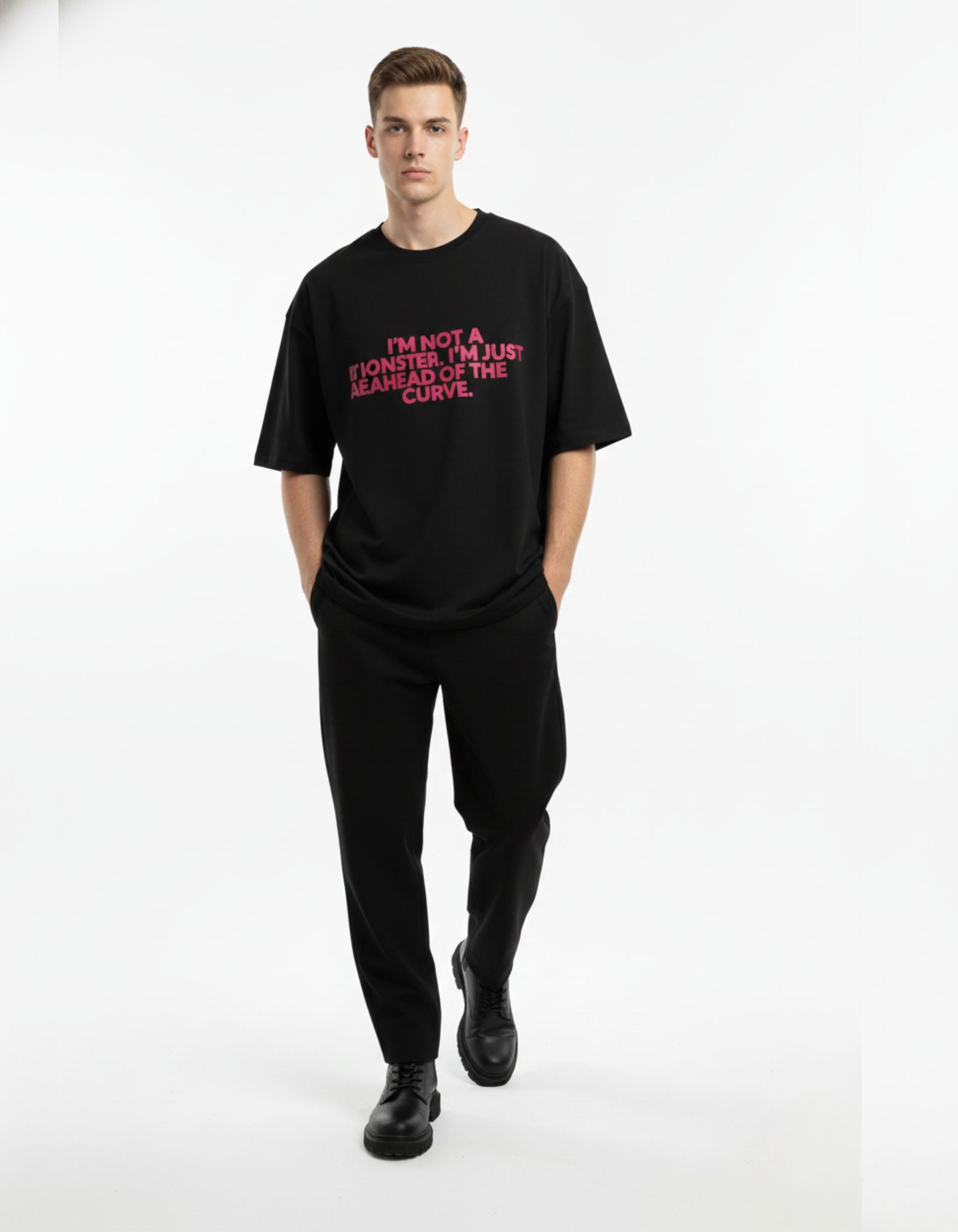 Man wearing black oversized graphic printed t-shirt with pink "I'm Not A Monster" quote for Indian streetwear look.
