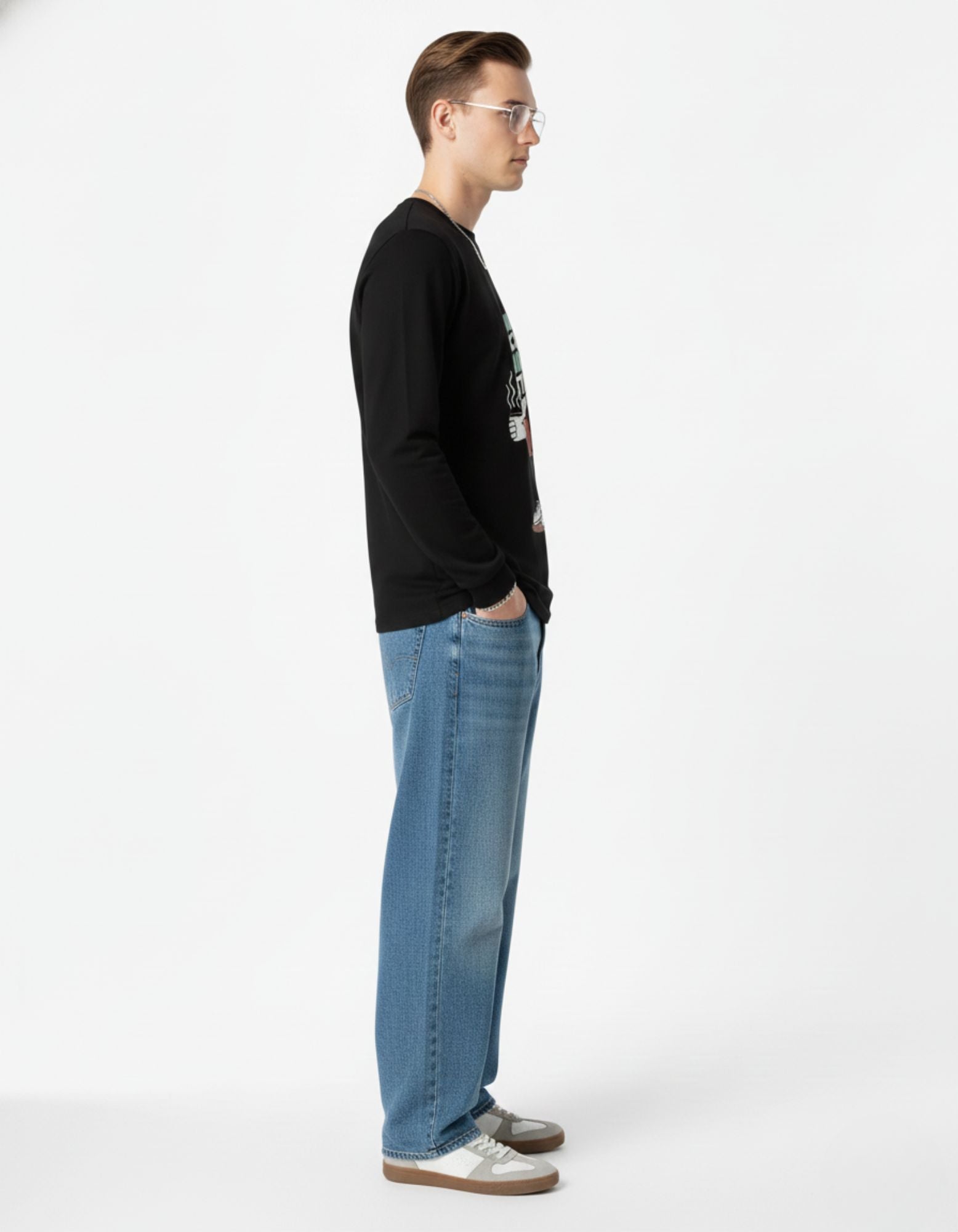 Side view of an aesthetic Indian streetwear outfit featuring a black long-sleeve graphic top and light-wash baggy denim jeans.