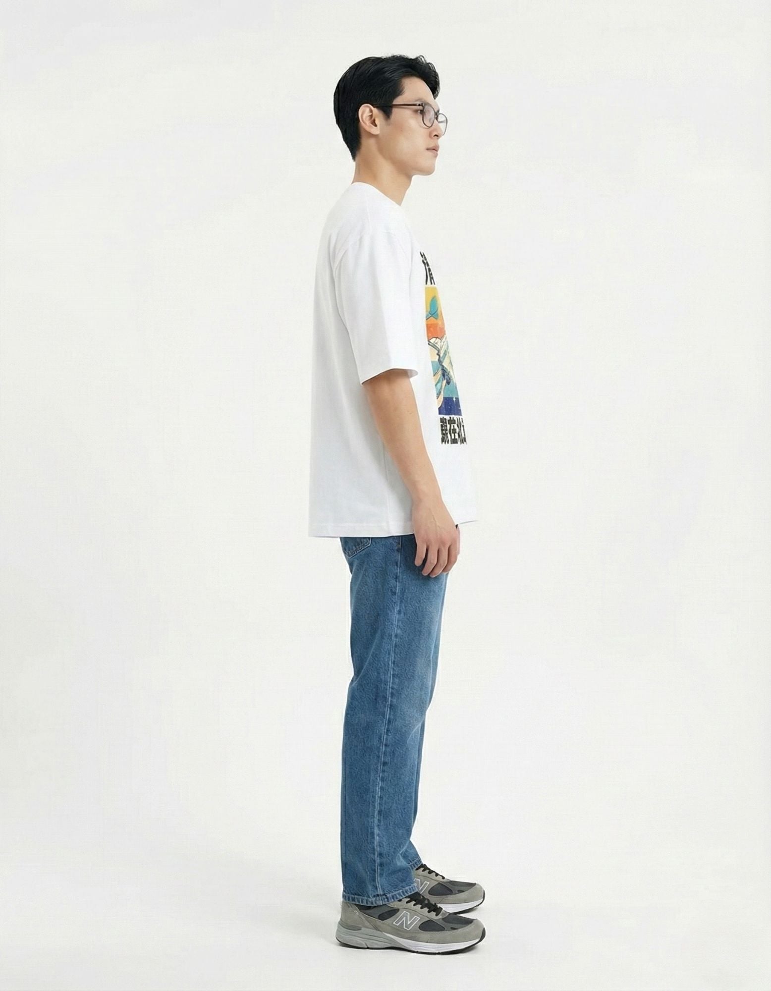 "Profile shot of male model wearing a white oversized t-shirt with a vintage-inspired space graphic print."