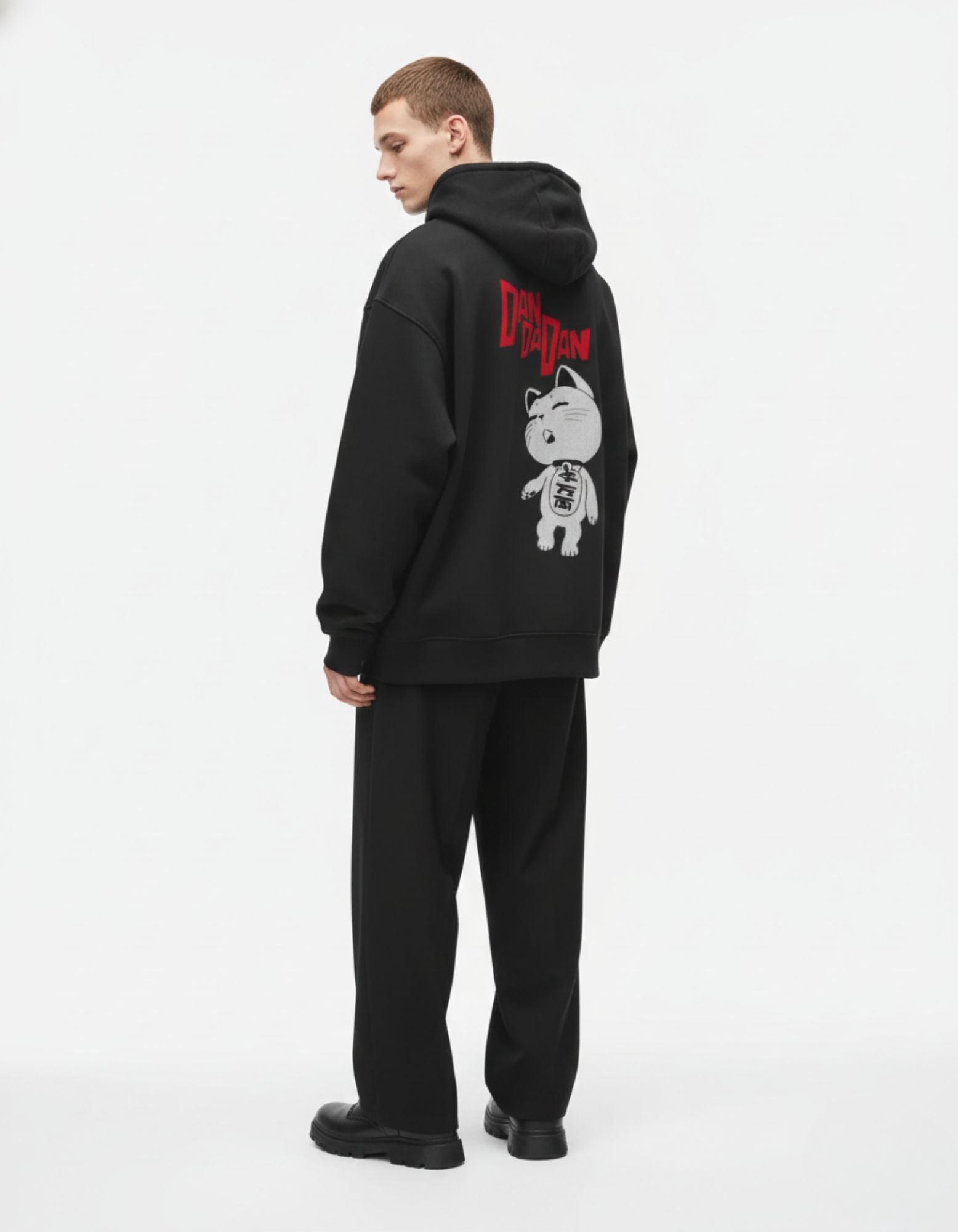 Male model wearing a black heavyweight Dandadan anime hoodie by GENZs Fashion, premium shonen-inspired streetwear.