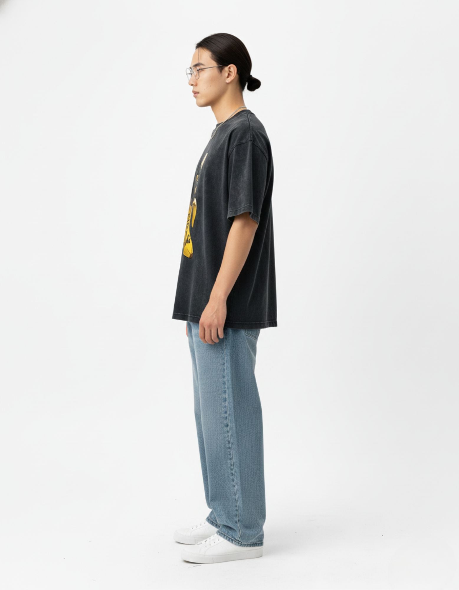 Side profile of a male model in a charcoal oversized t-shirt showing the heavyweight fabric and relaxed street style.