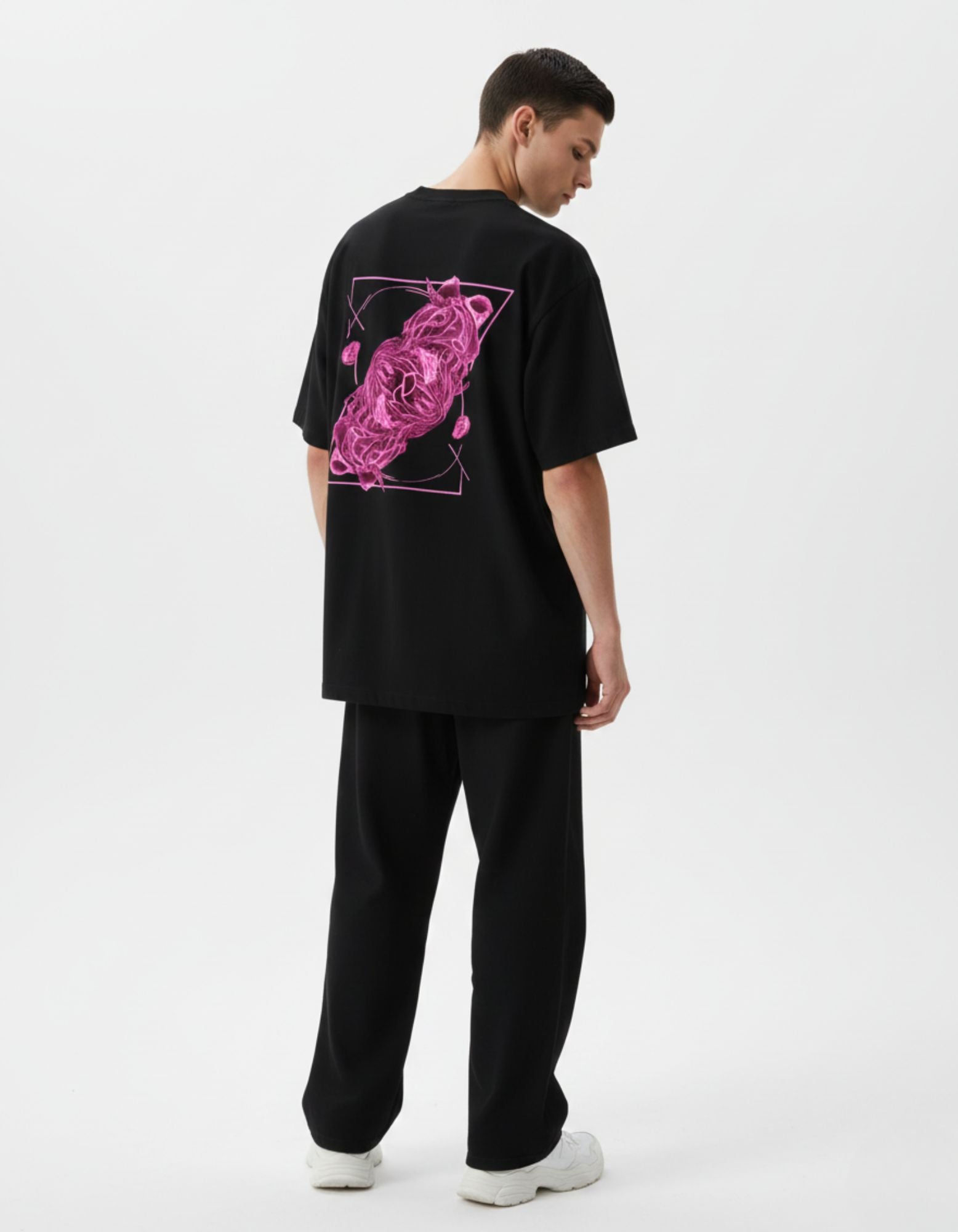 Male model wearing a GENZs Fashion black t-shirt featuring a vibrant pink neon abstract graphic back print.