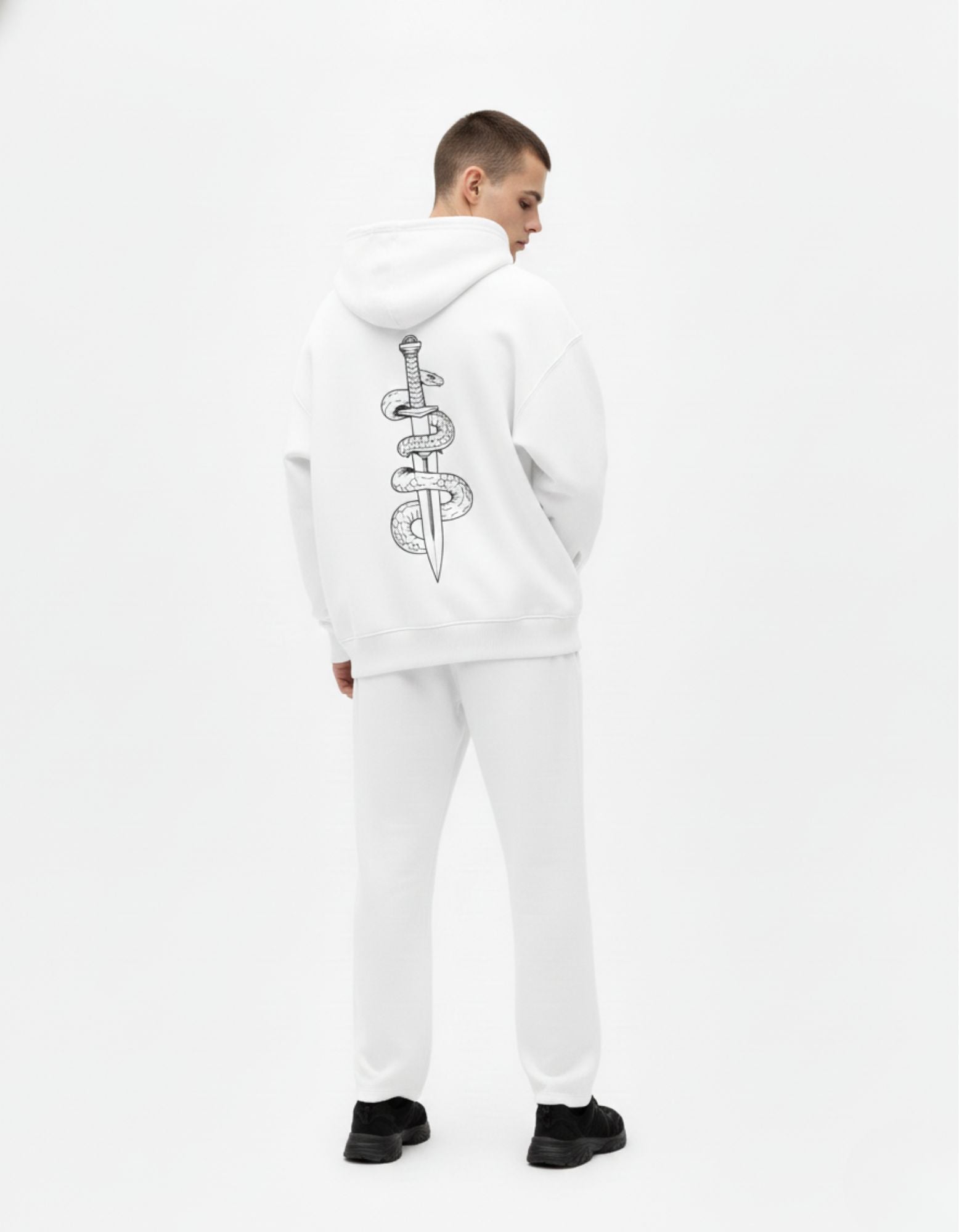 Back profile of a male model wearing the GENZs Fashion signature snake and dagger graphic hoodie in white.
