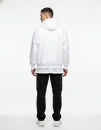 Back view of a male model in an oversized white graphic hoodie, showing the relaxed fit and high-quality fabric.