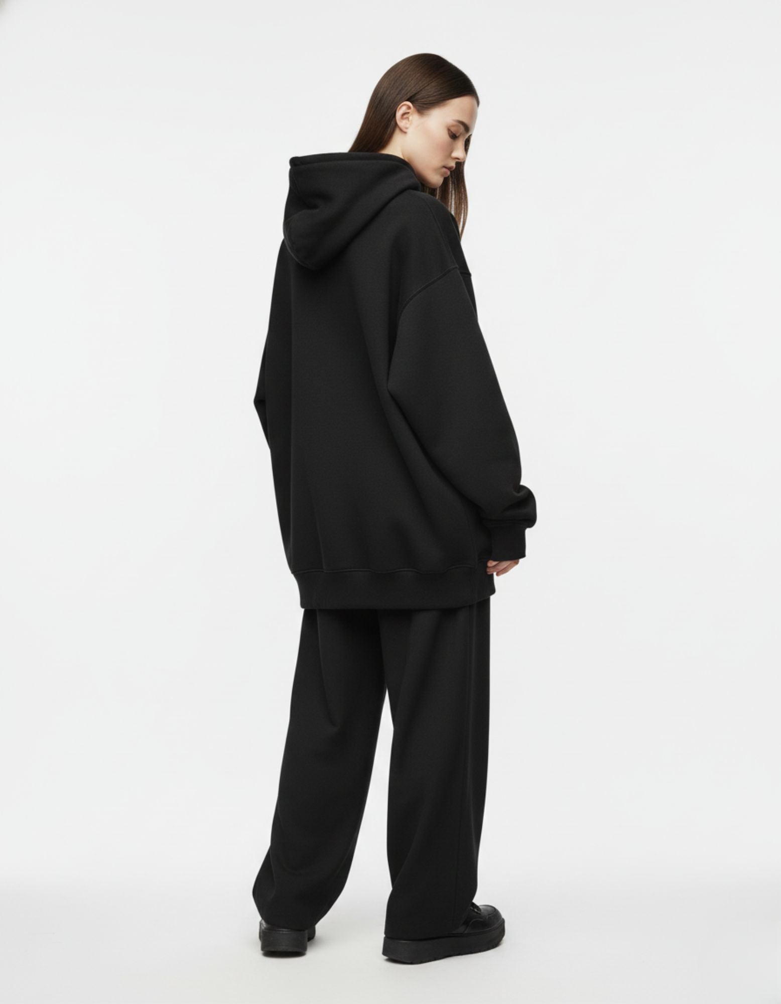 Back view of a minimalist black anime-aesthetic hoodie for women, showing the clean finish and loose Gen Z fit.