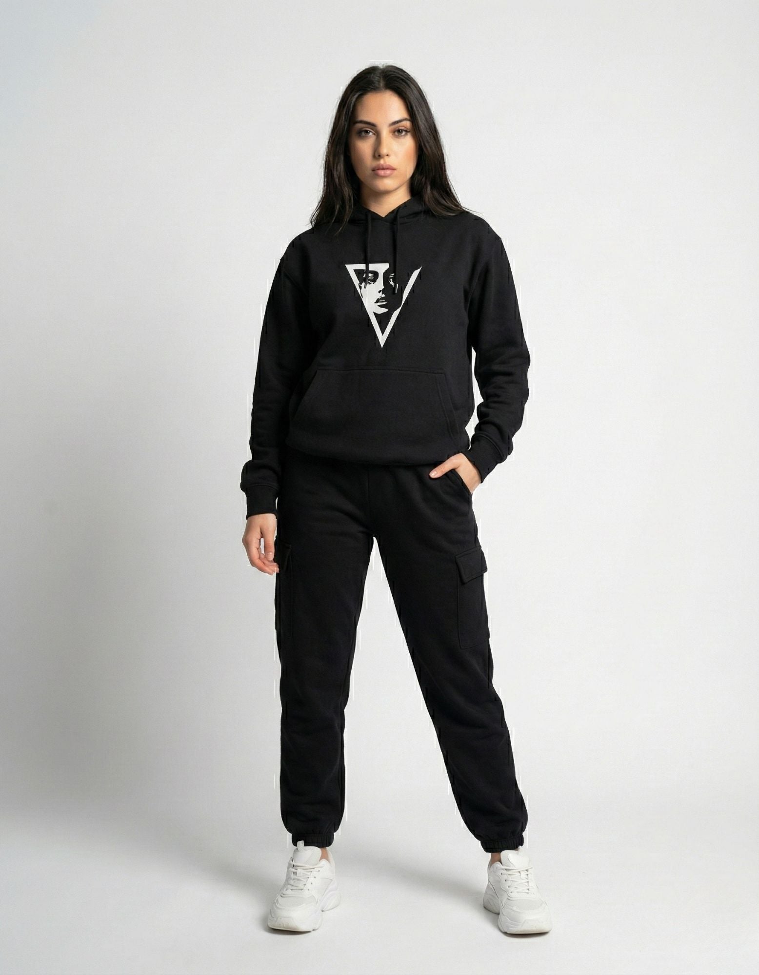 Front full-body view of a female model wearing a black GENZs Fashion hoodie with a minimalist triangle face graphic.