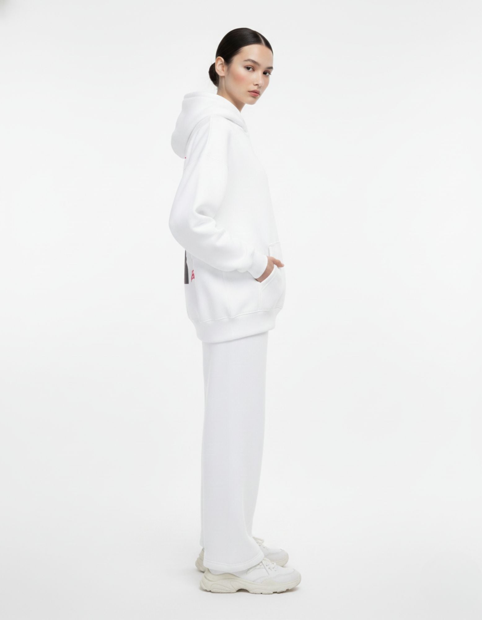 Side profile of female model wearing a white GENZs Fashion oversized hoodie, showing the clean silhouette and premium fabric.