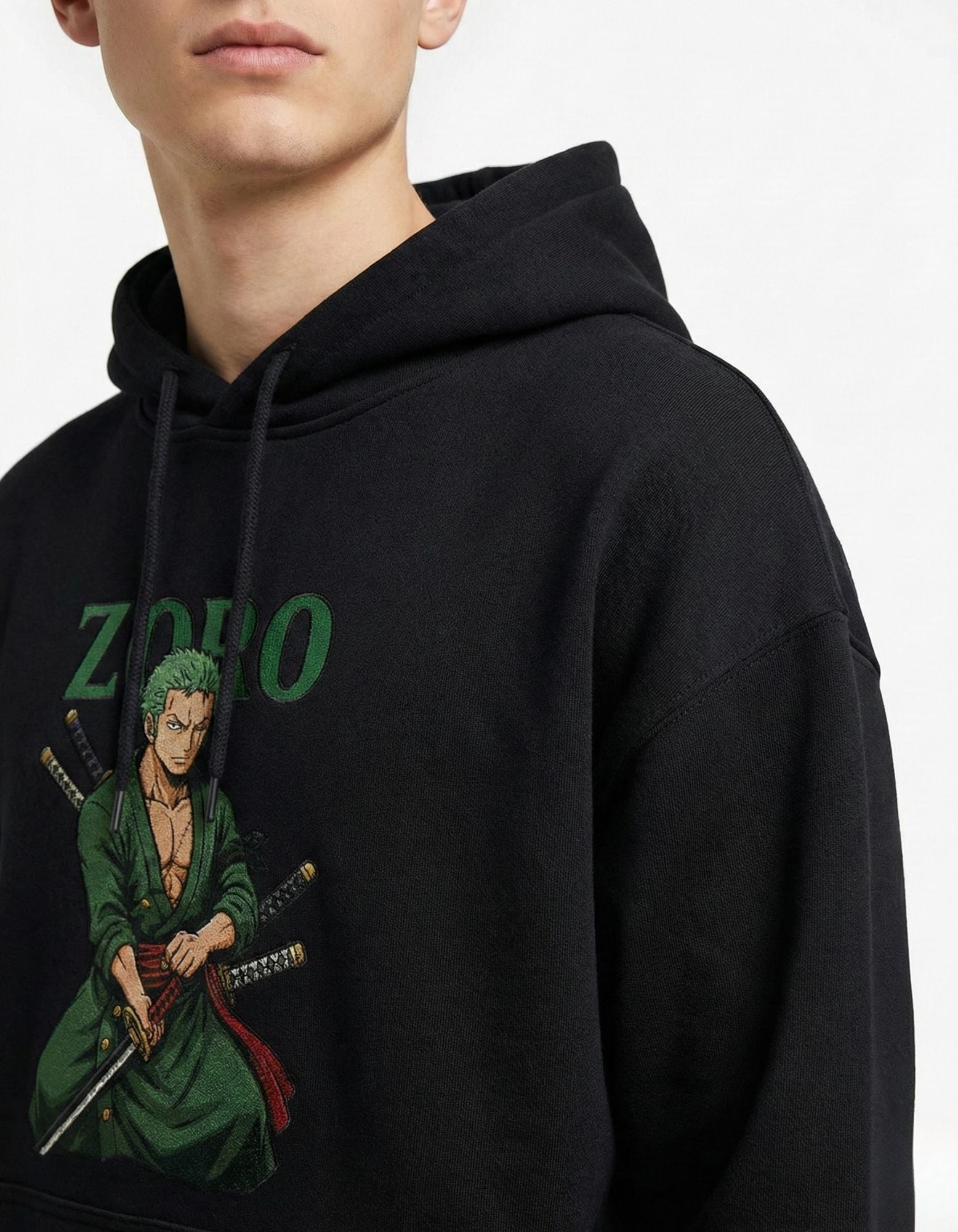 Close-up detail of the Roronoa Zoro character print on a premium black heavyweight cotton hoodie, highlighting the vibrant green accents.