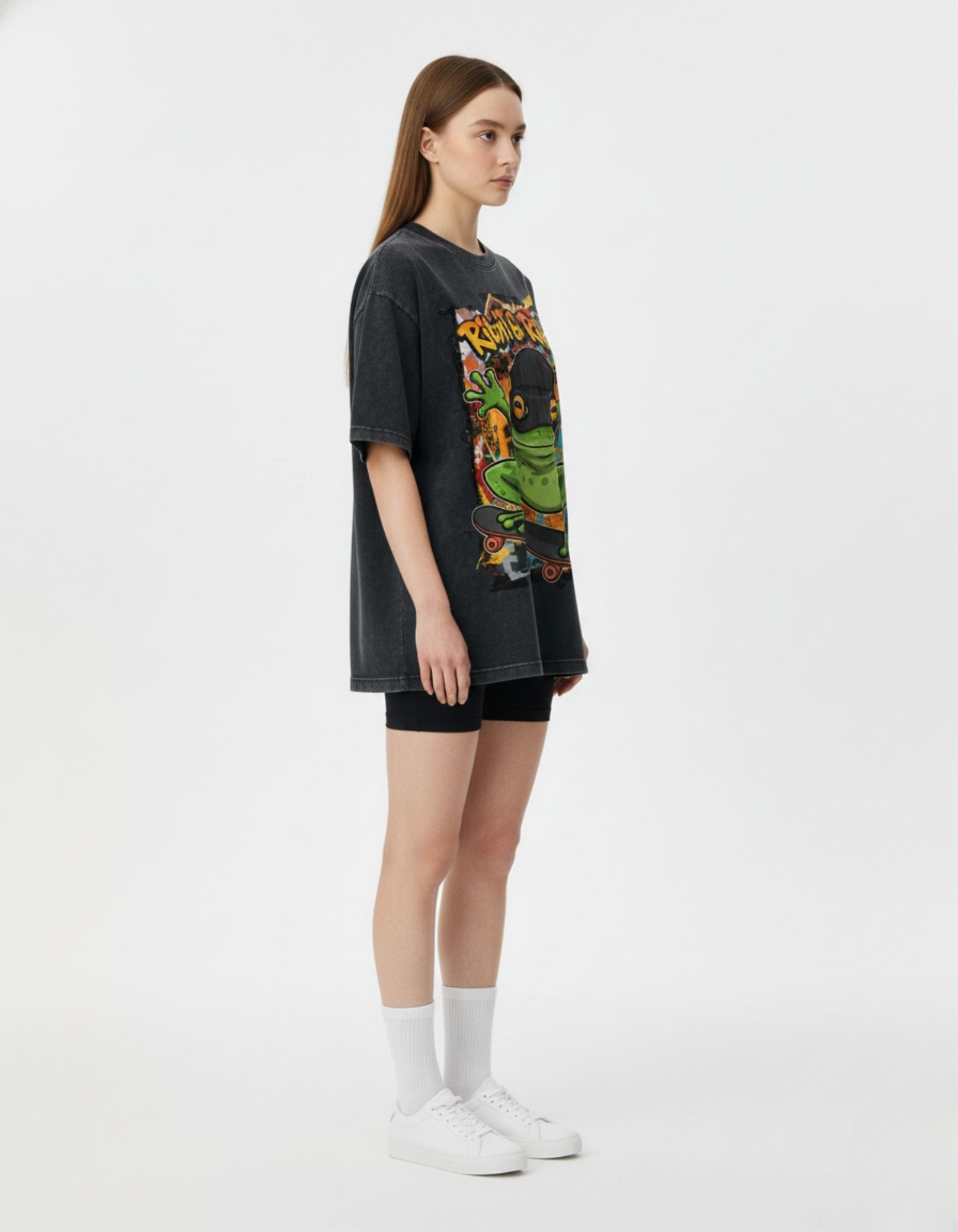 Side view of a female model wearing the oversized boxy fit streetwear t-shirt in charcoal black for a modern urban aesthetic.